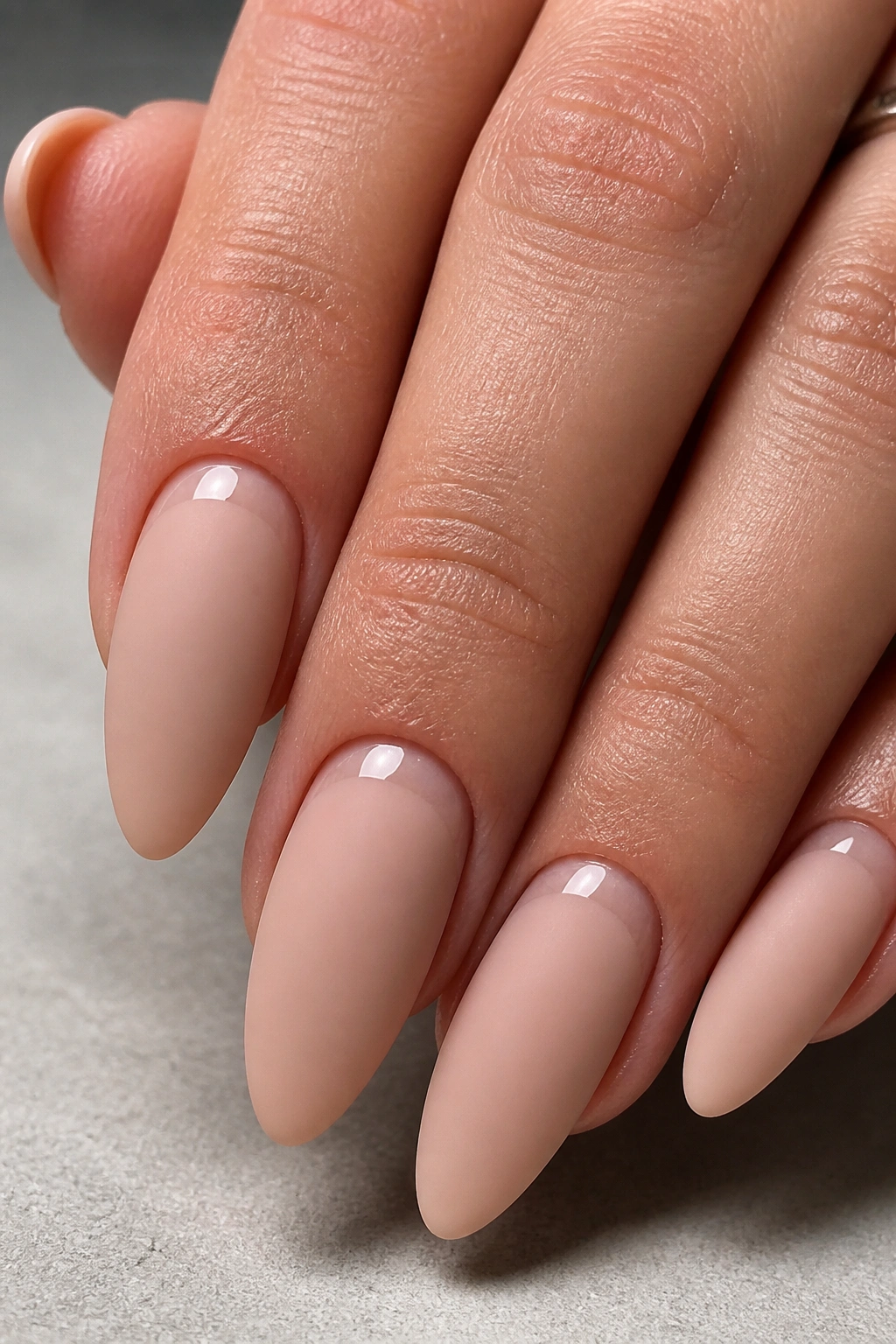 Close-up of matte almond nails with gloss cuticle detail on a real hand