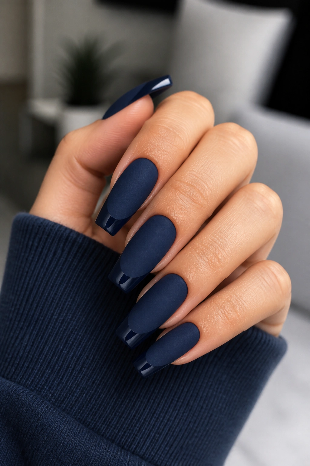 Close-up of a real hand with matte navy nails and glossy navy French tips
