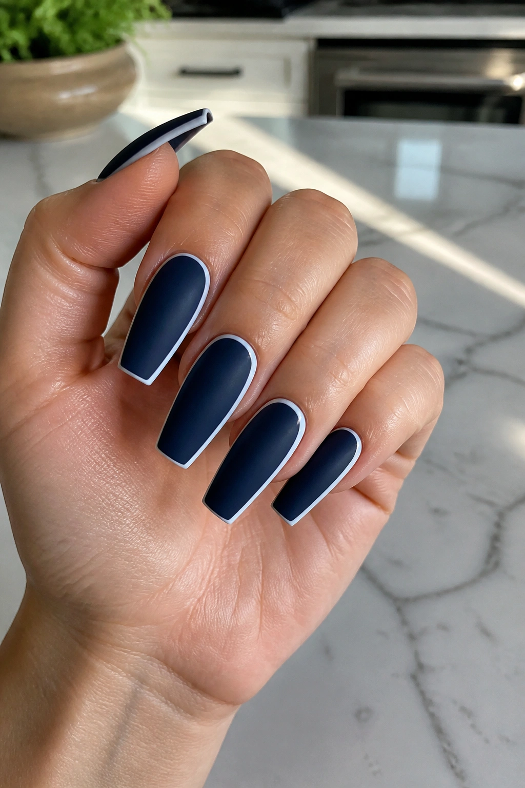 Matte navy coffin nails with white outlines in natural light
