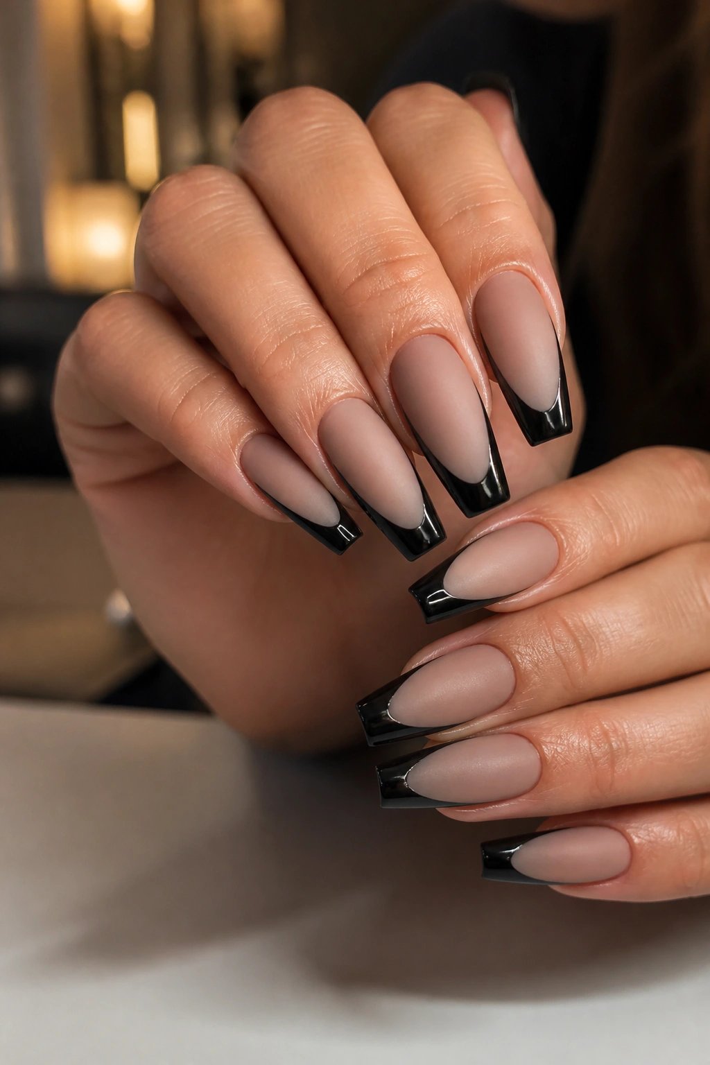 Close-up of matte nude coffin nails with glossy black edges