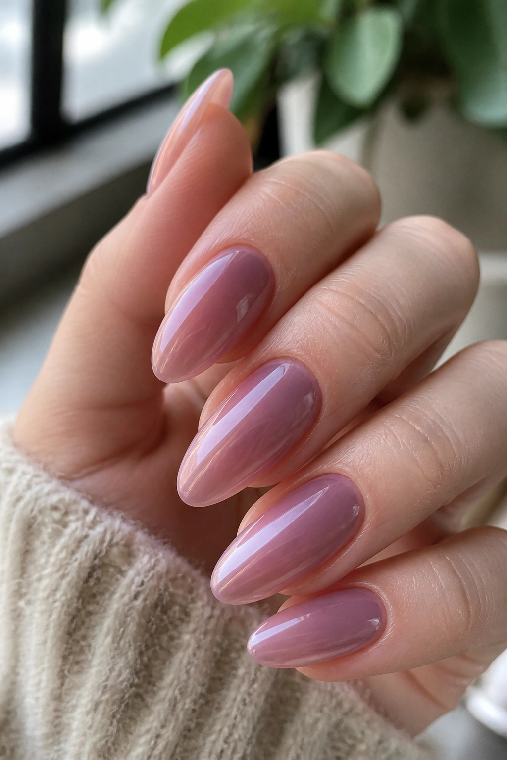 Close-up of mauve jelly almond nails with pearl glow on a real hand.