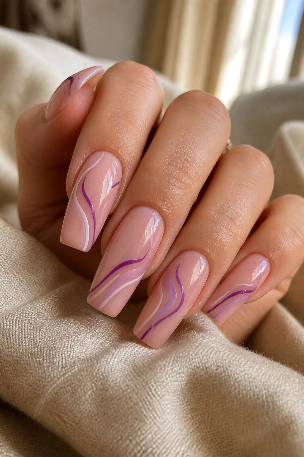 Mauve nude coffin nails with purple swirl lines close-up