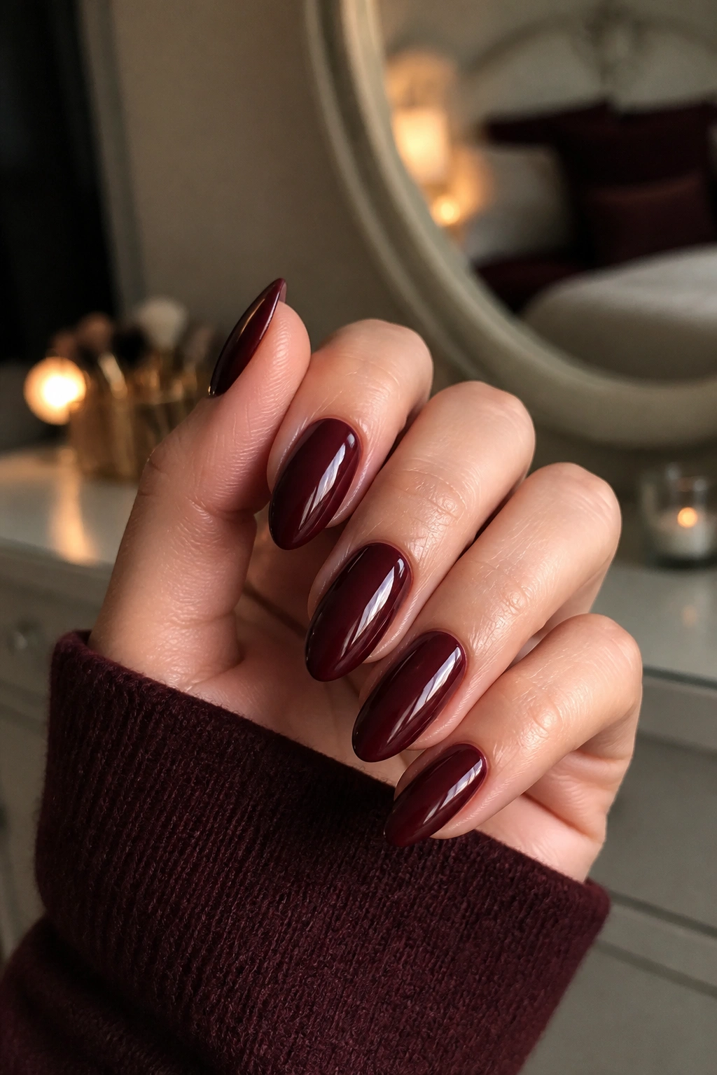 Close-up of merlot almond nails on a real hand with glossy finish.