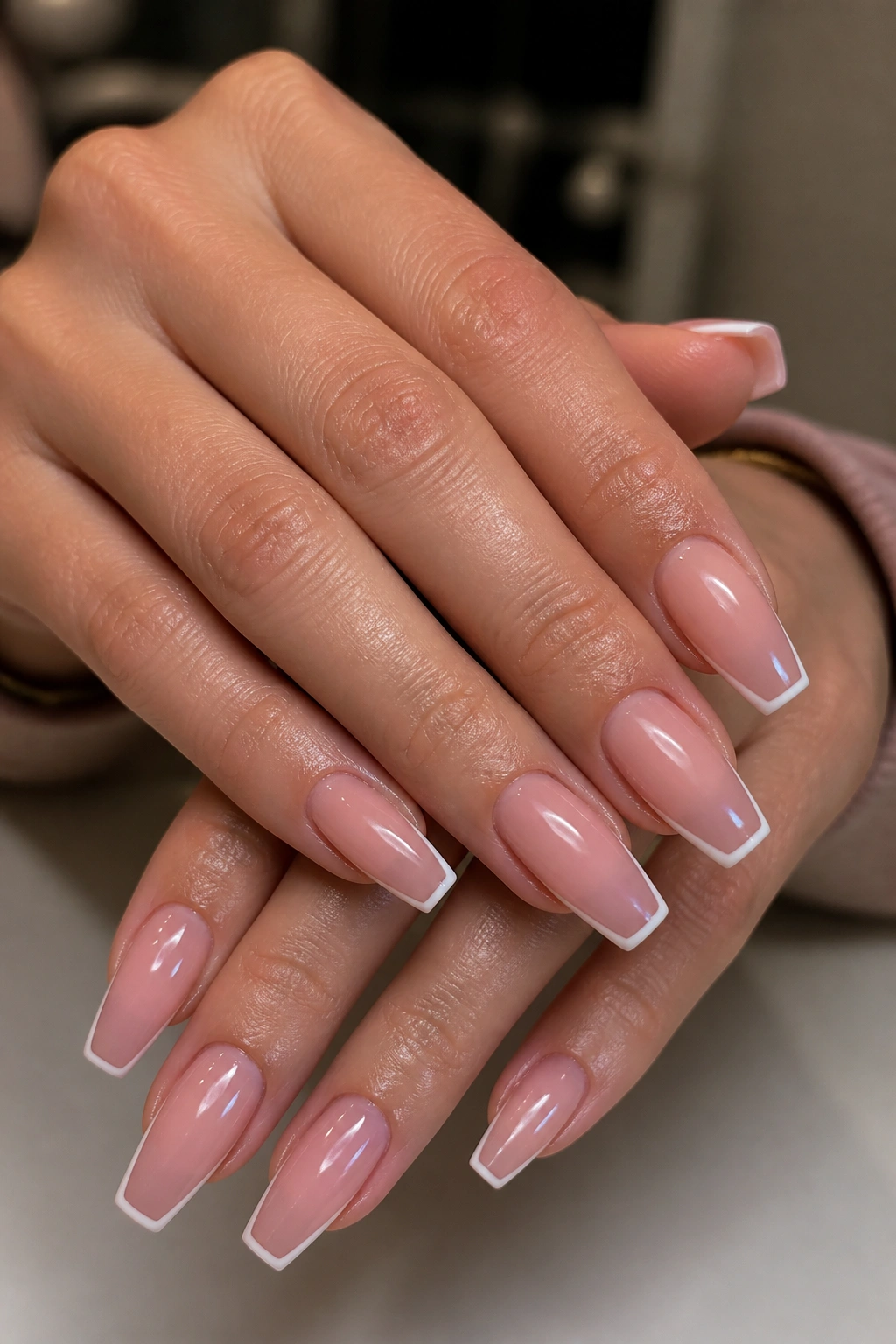 Close-up of hands with micro French coffin nails showing hairline white edges.