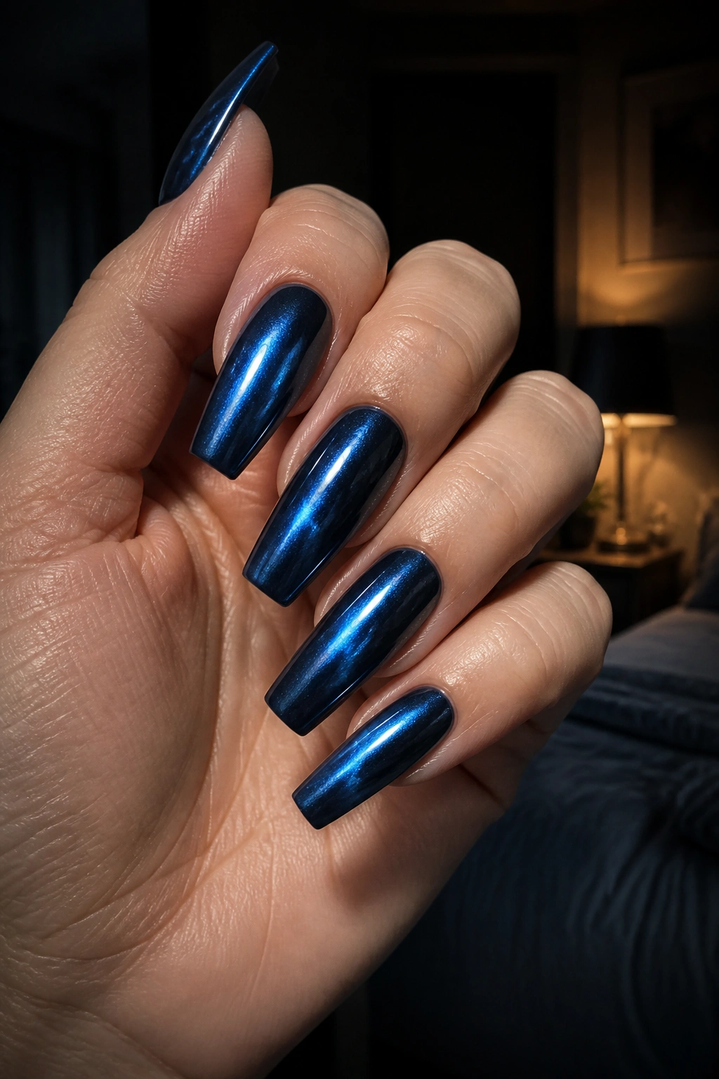 Close-up of midnight blue cat-eye chrome coffin nails on a real hand