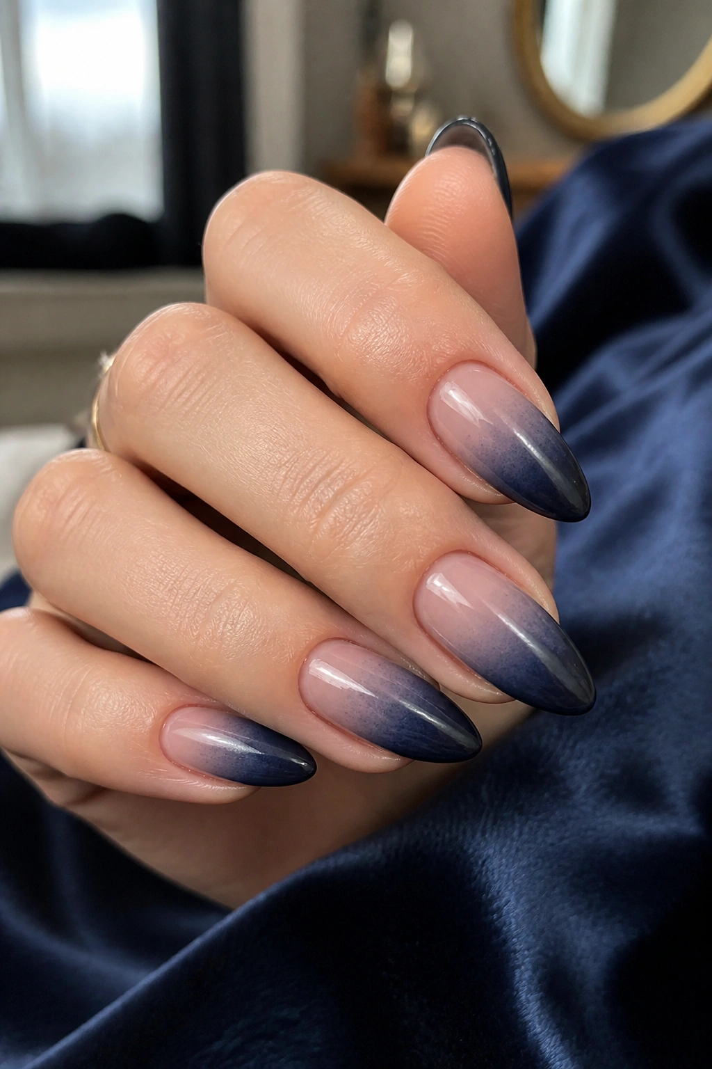 Close-up of almond-shaped nails in midnight navy ombre with glossy finish