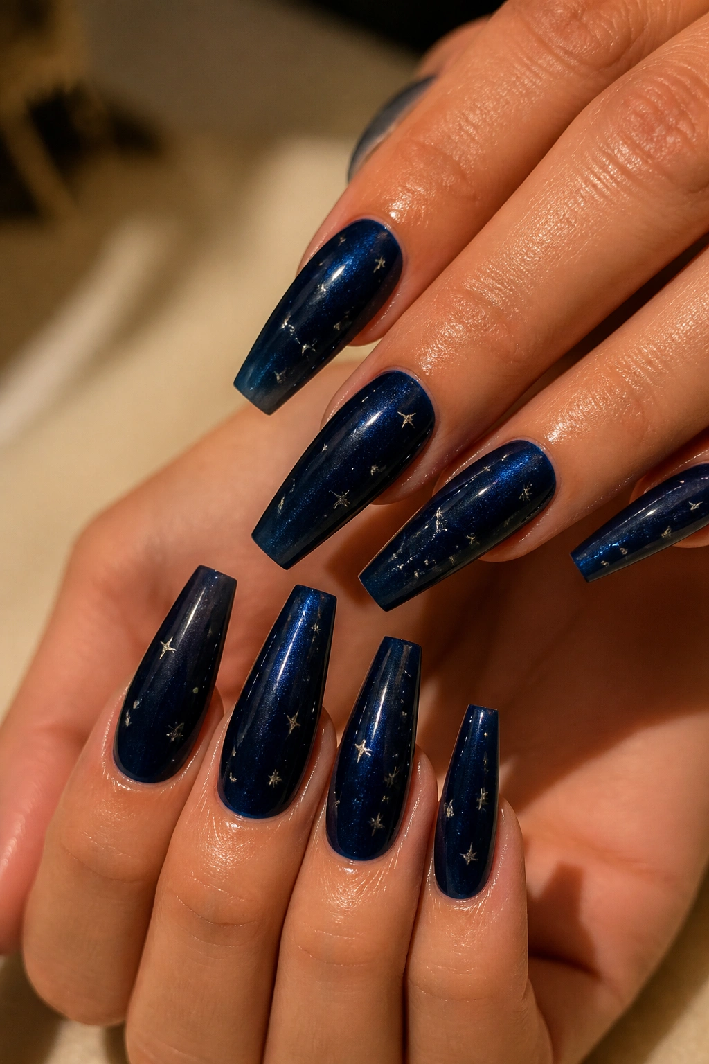 Midnight navy coffin nails with tiny silver stars on real person's hands