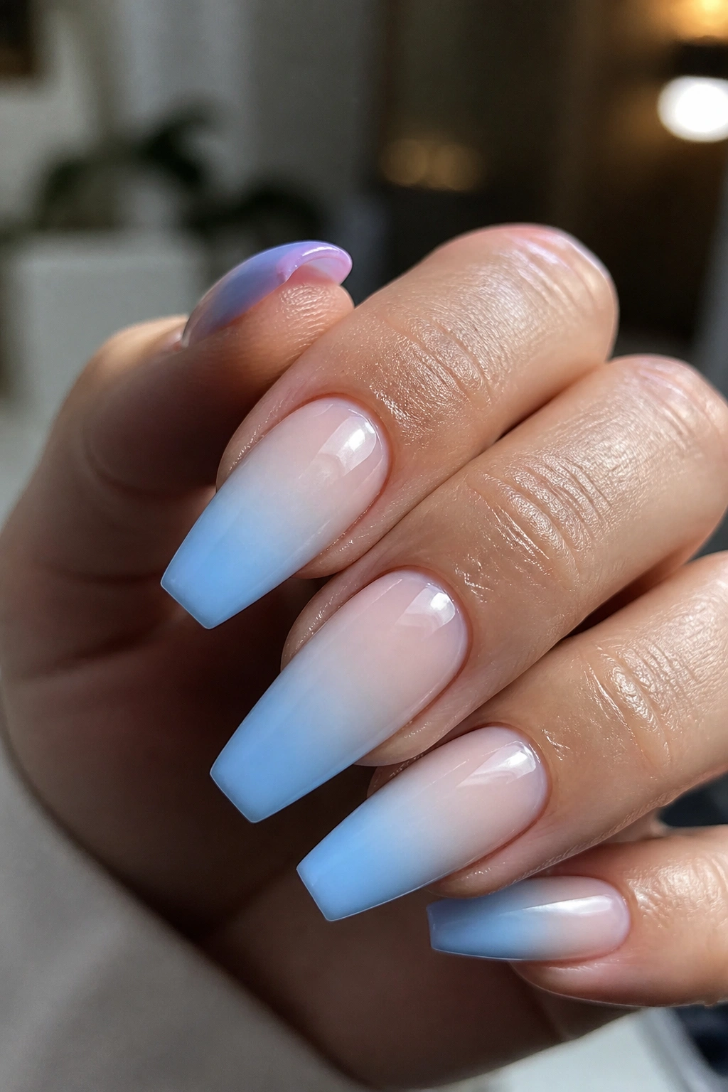 Real hand with milky blue ombré coffin nails