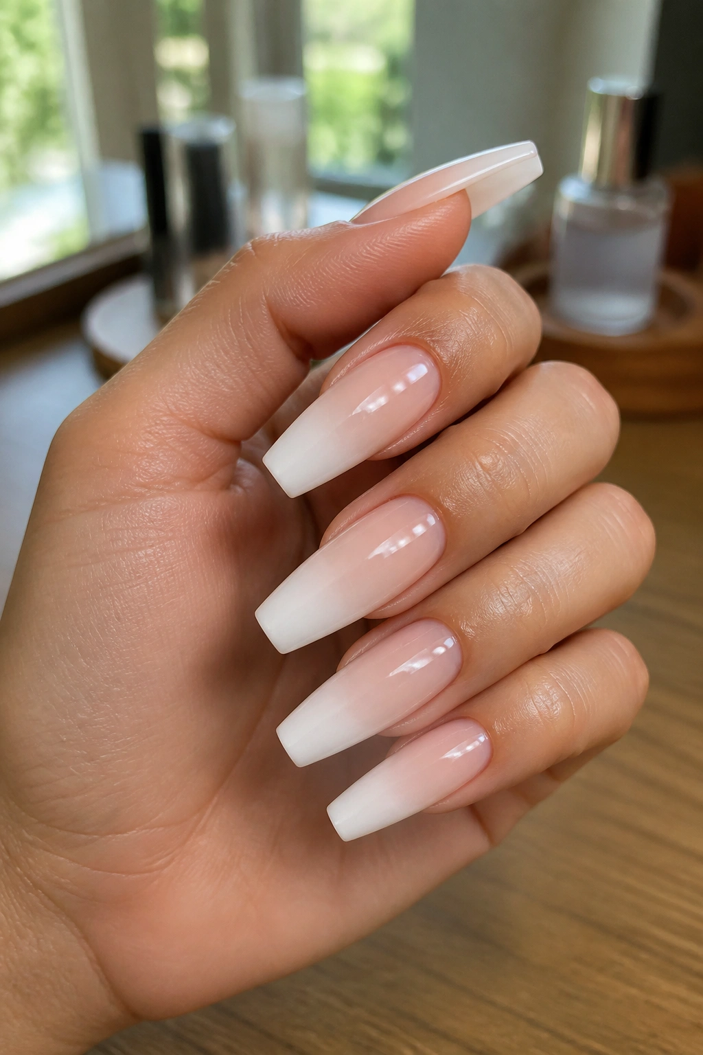 Close-up of milky white coffin nails with a deep smile line on a real hand in a salon setting