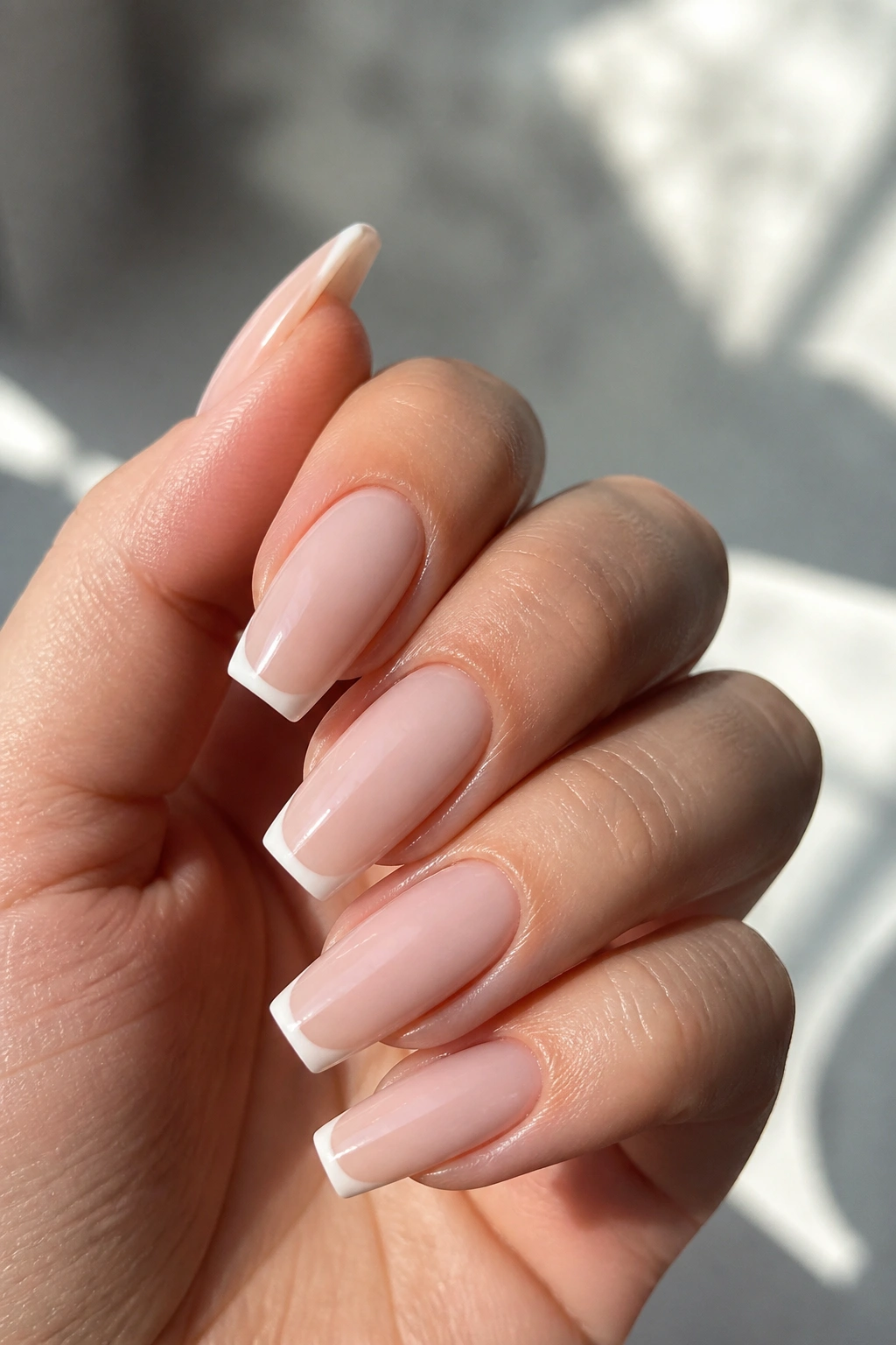 Milky nude coffin nails with micro French tips on real hand
