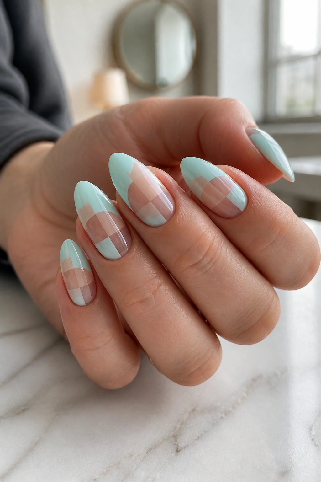 Close-up of real hand with almond nails featuring mint abstract color-block design