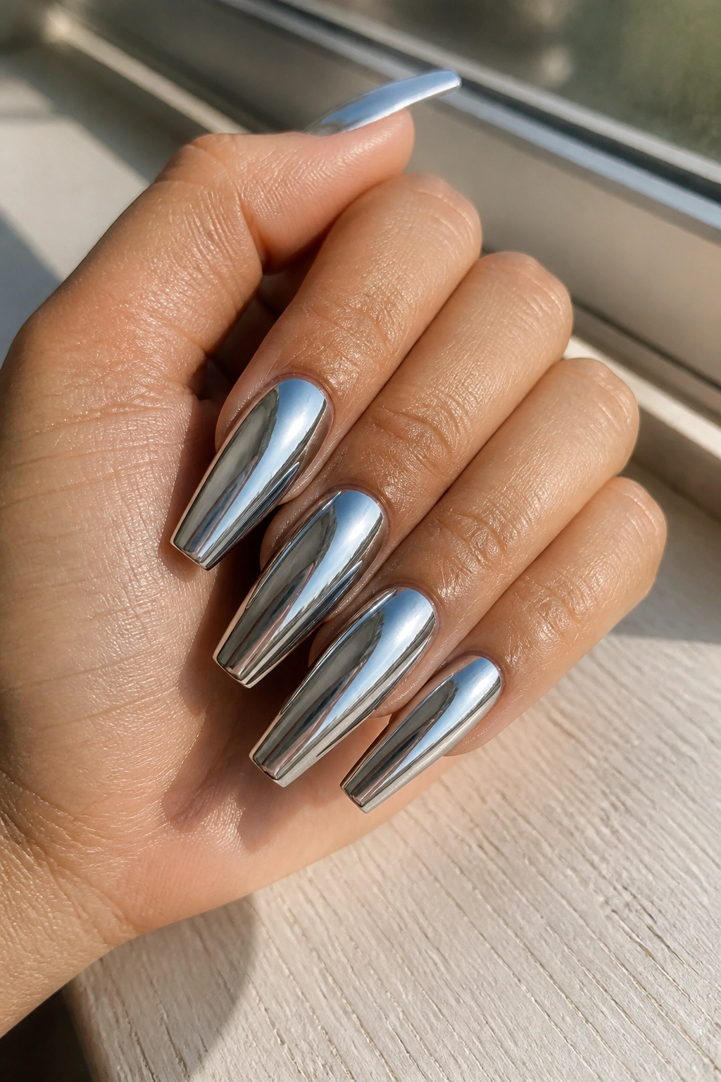 Close-up of mirror-chrome coffin nails on a real hand