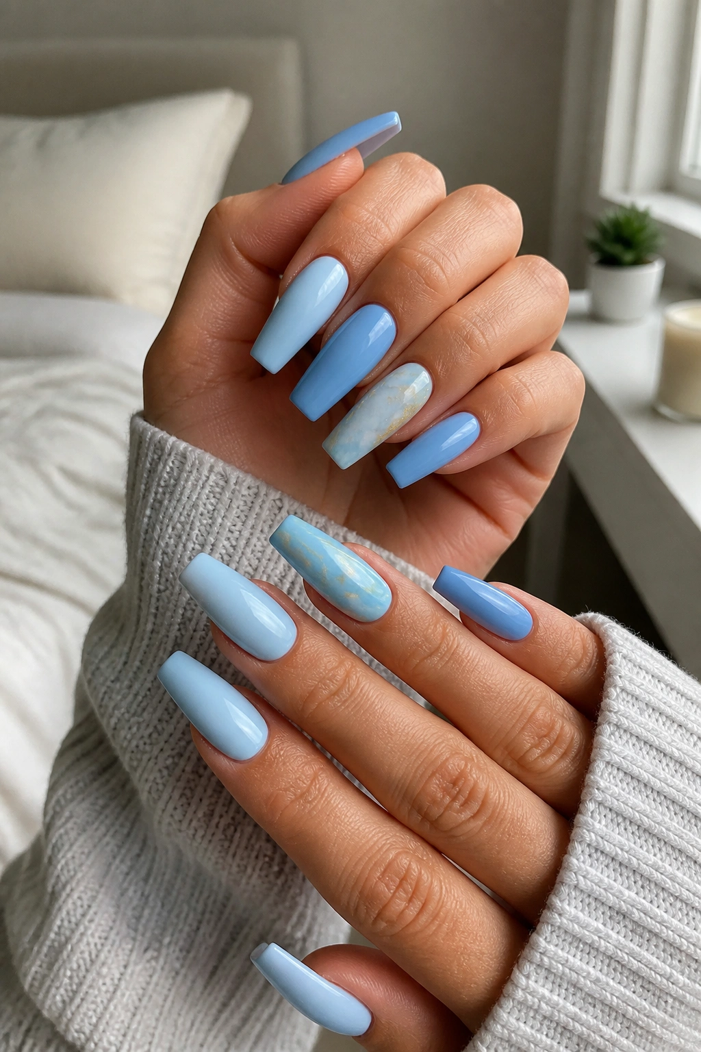 Close-up of mismatched light blue coffin nails on real hands showing different blue shades