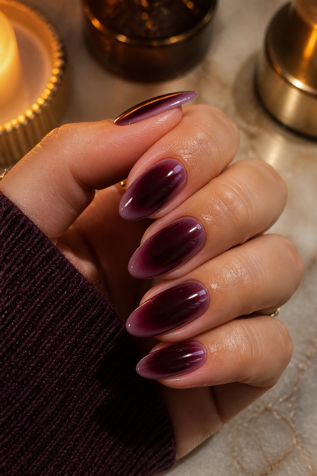 Close-up of almond nails with black cherry velvet aura gradient on a real hand