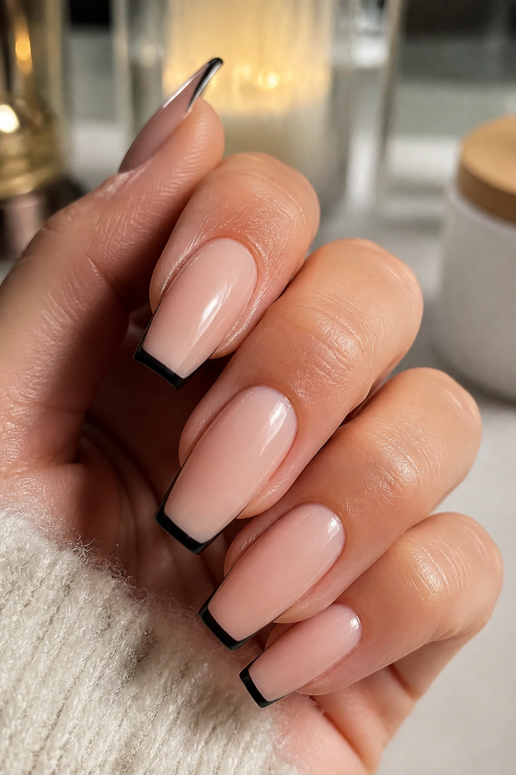 Close-up of coffin nails with black tips over natural nude base