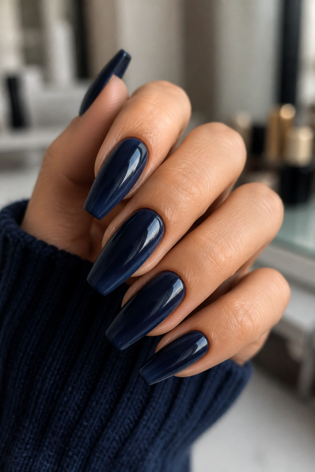 Close-up of navy aura nails with inky centers on a hand