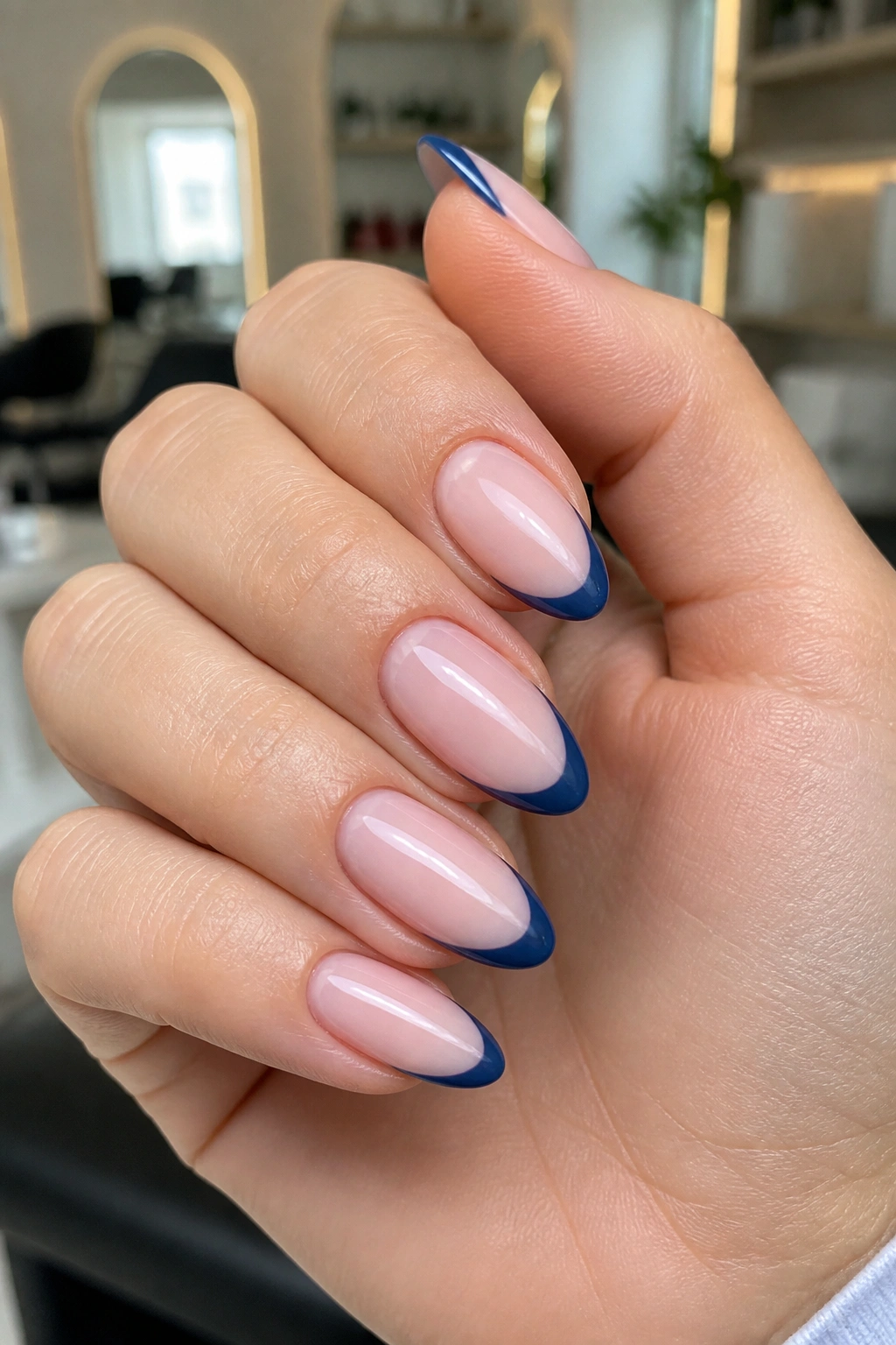 Navy French tips on sheer pink base nails close-up on real hand