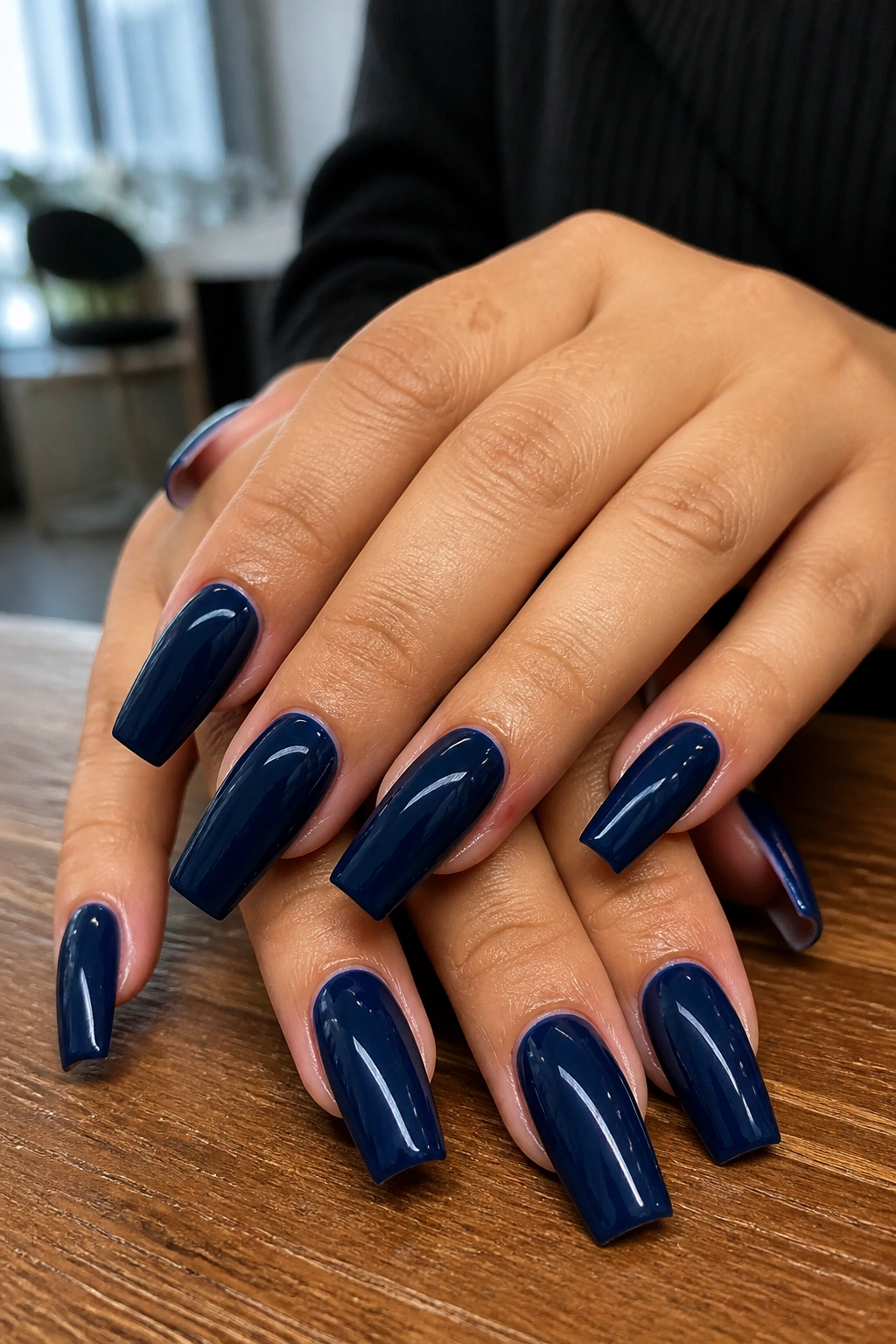 Close-up of navy coffin nails on a real hand in a chic salon
