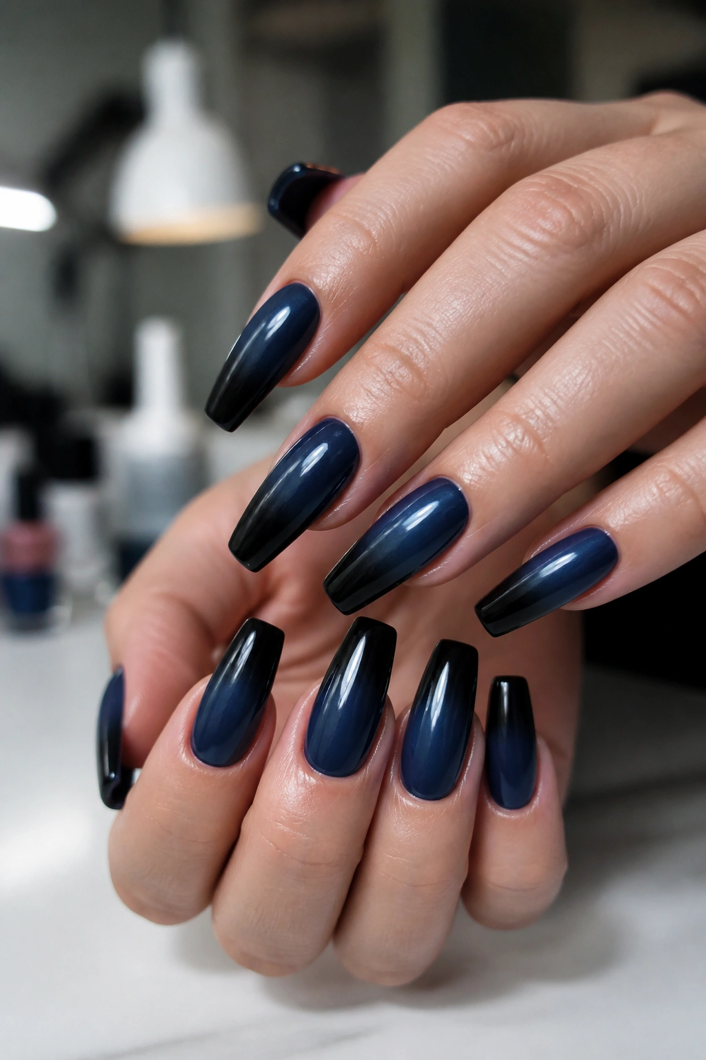 Navy to black ombré coffin nails on a real hand with soft lighting