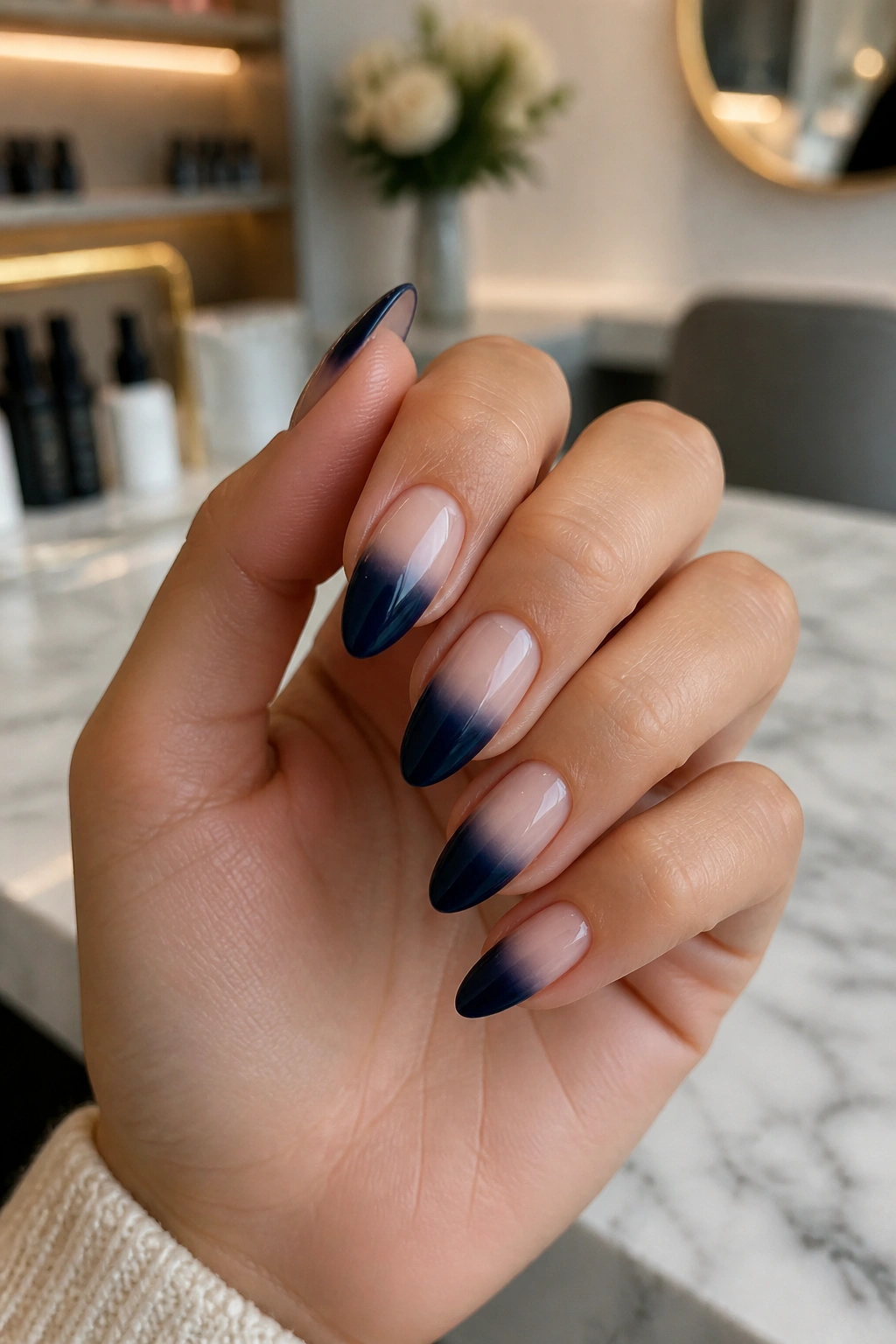 Almond nails with navy to nude ombre fade in natural daylight