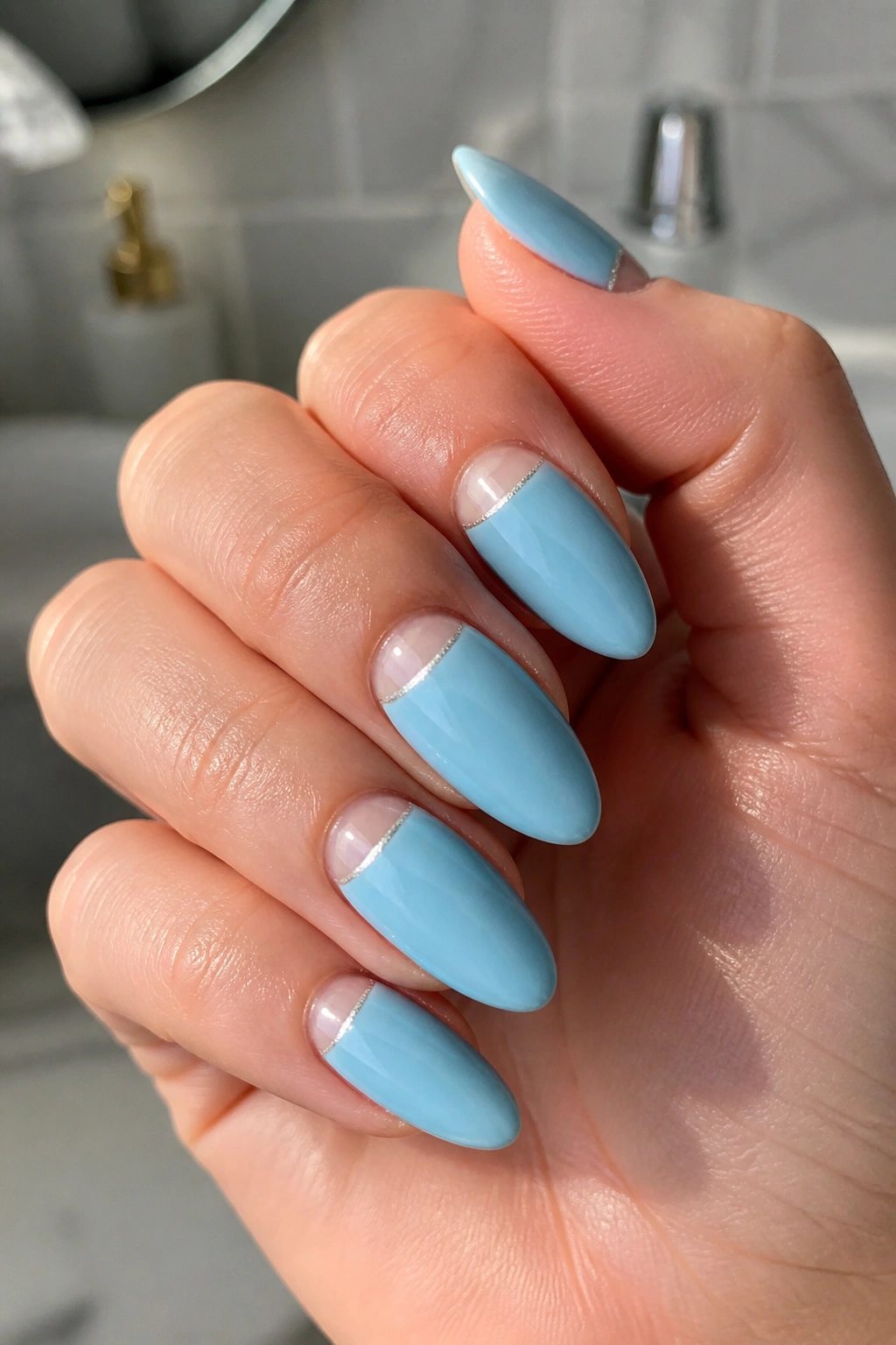 Close-up of almond nails with negative space half-moon blue design