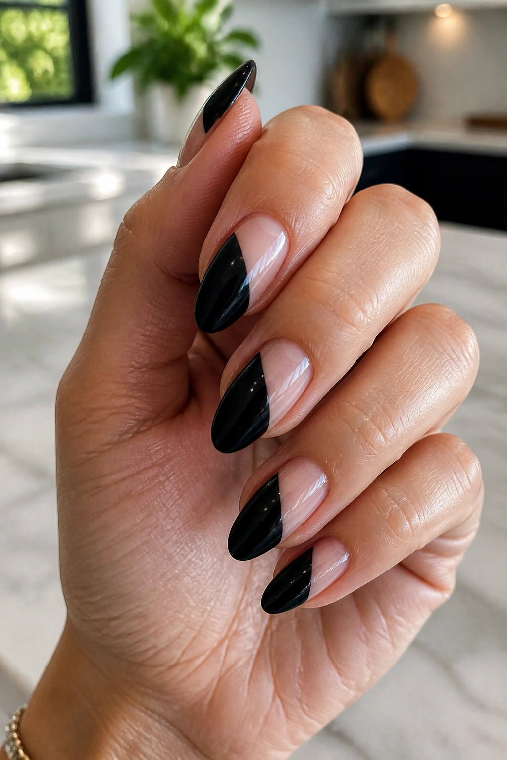Close-up of black almond nails with a diagonal negative-space slash