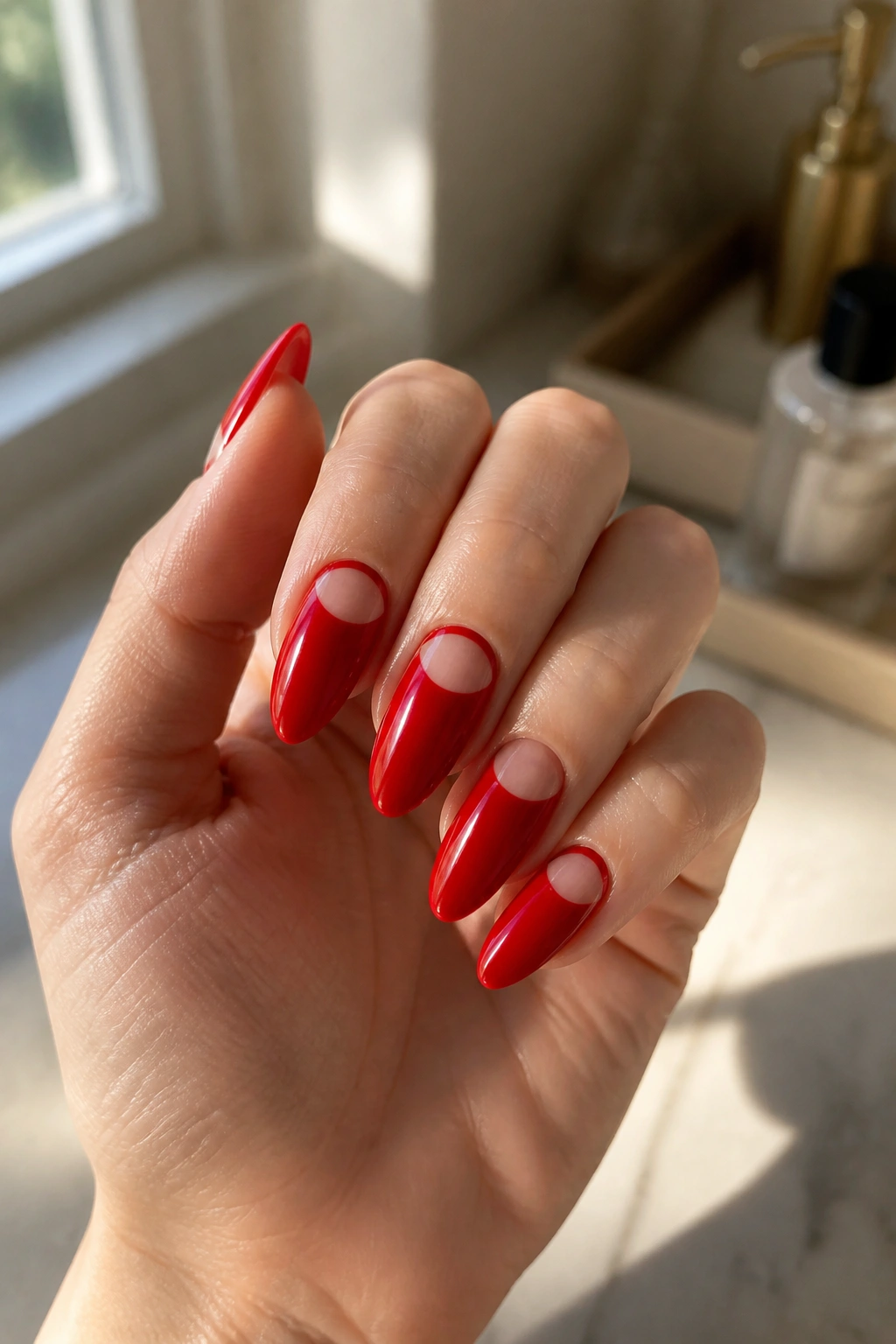 Close-up of long almond nails with a red crescent near the cuticle on a real hand