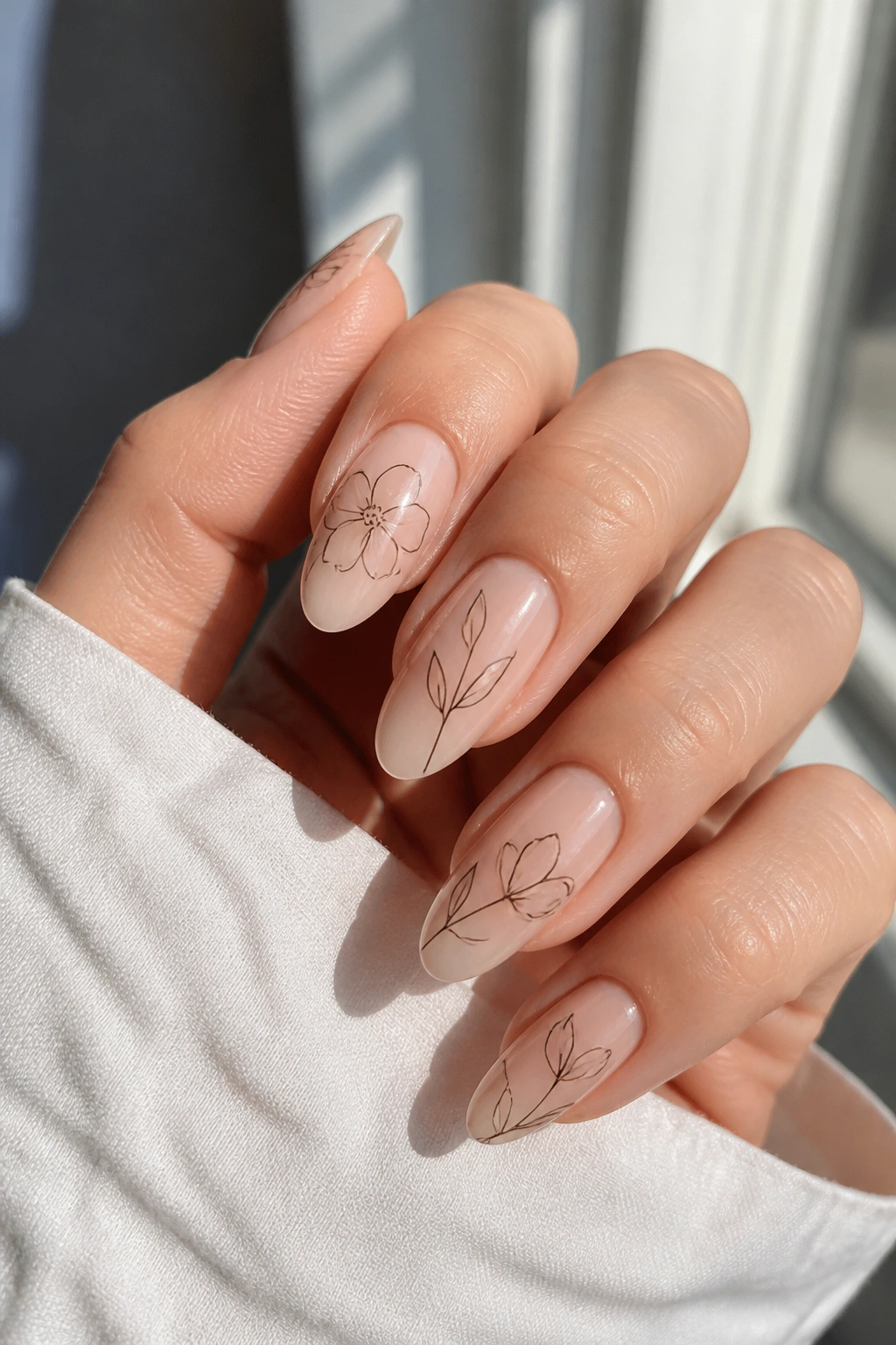 Almond nails with clear base and thin floral outlines