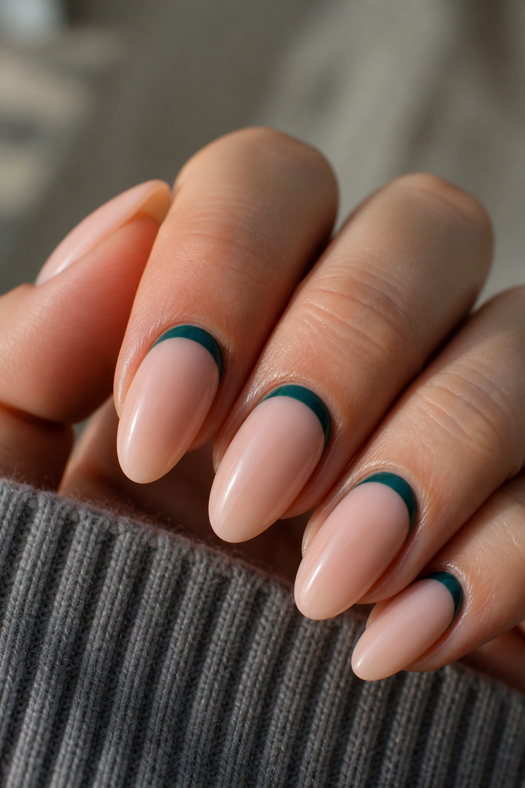Almond nails with teal crescents and negative space near the base