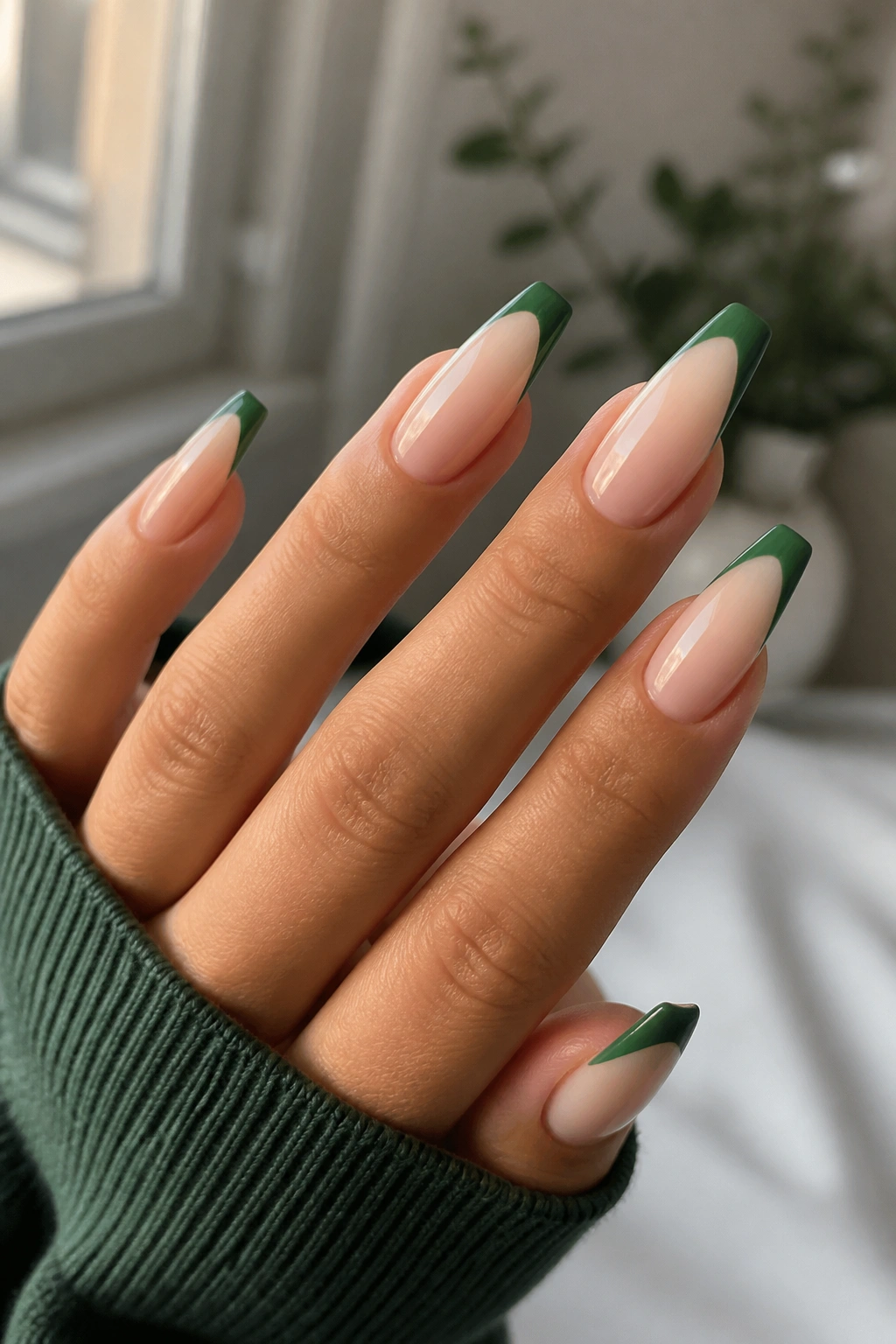 Close-up of nails showing nude base with slim green tip.