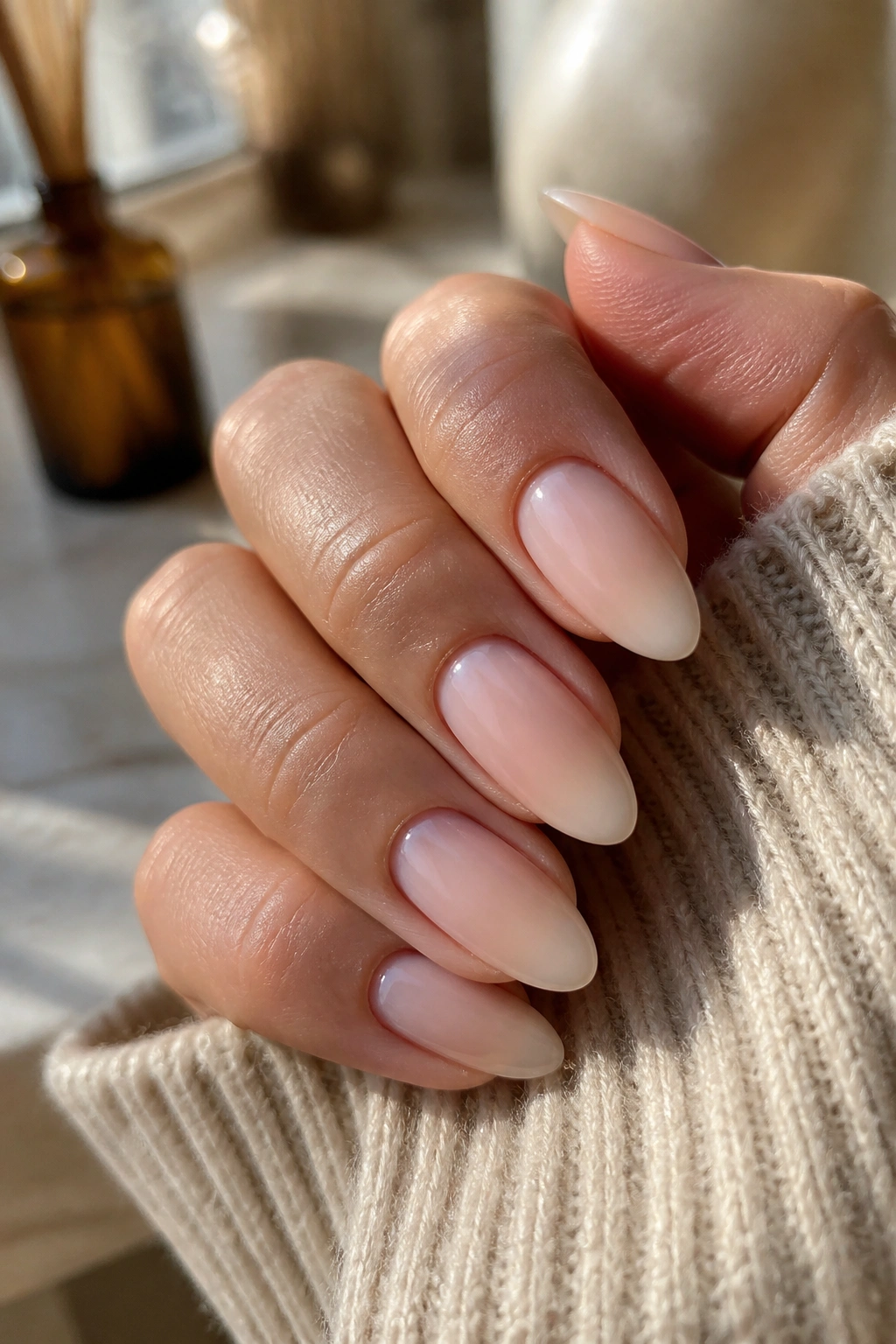 Close-up of everyday nude ombre almond nails showing light growth near cuticles