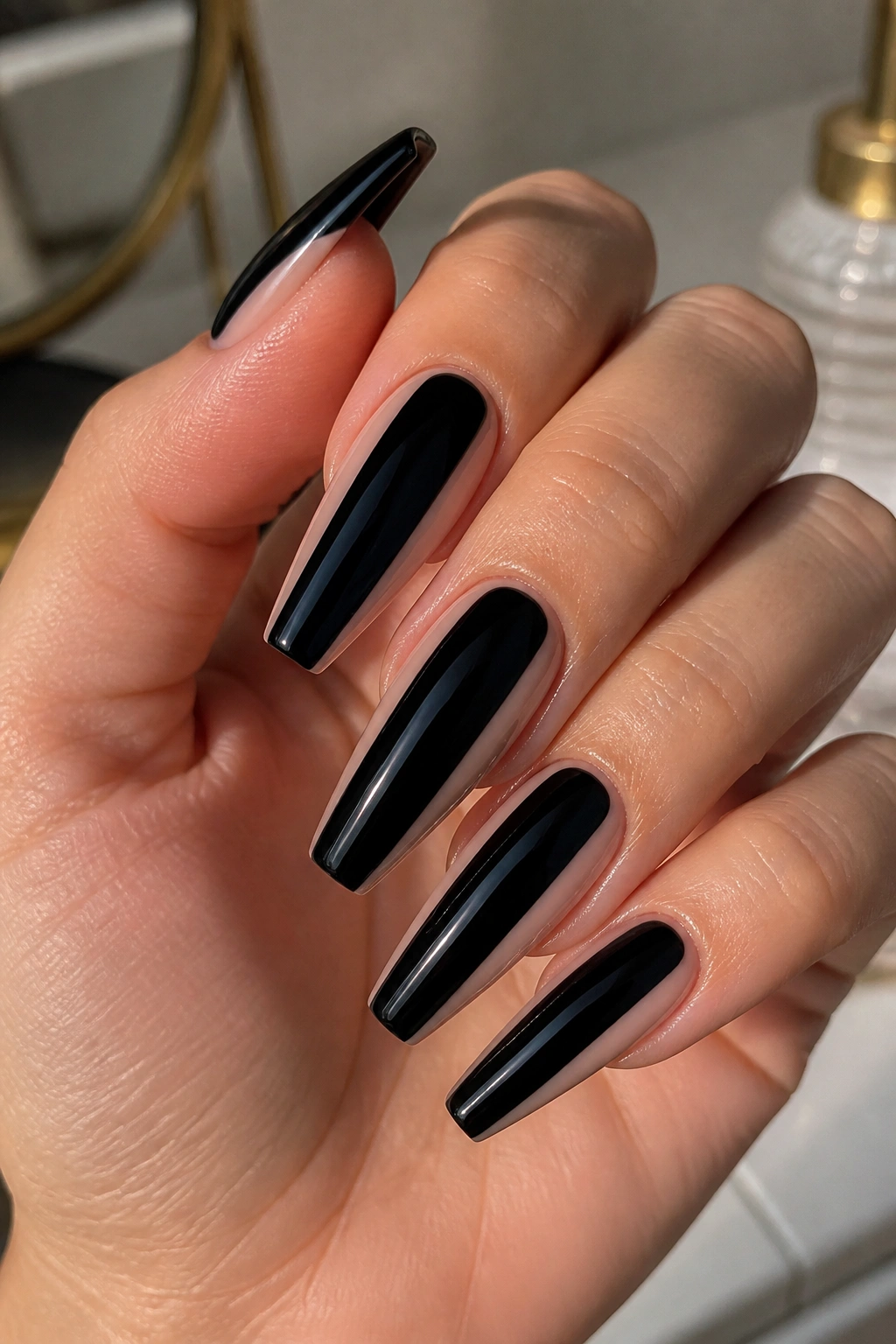 Close-up of black coffin nails with nude side cutouts on a hand.