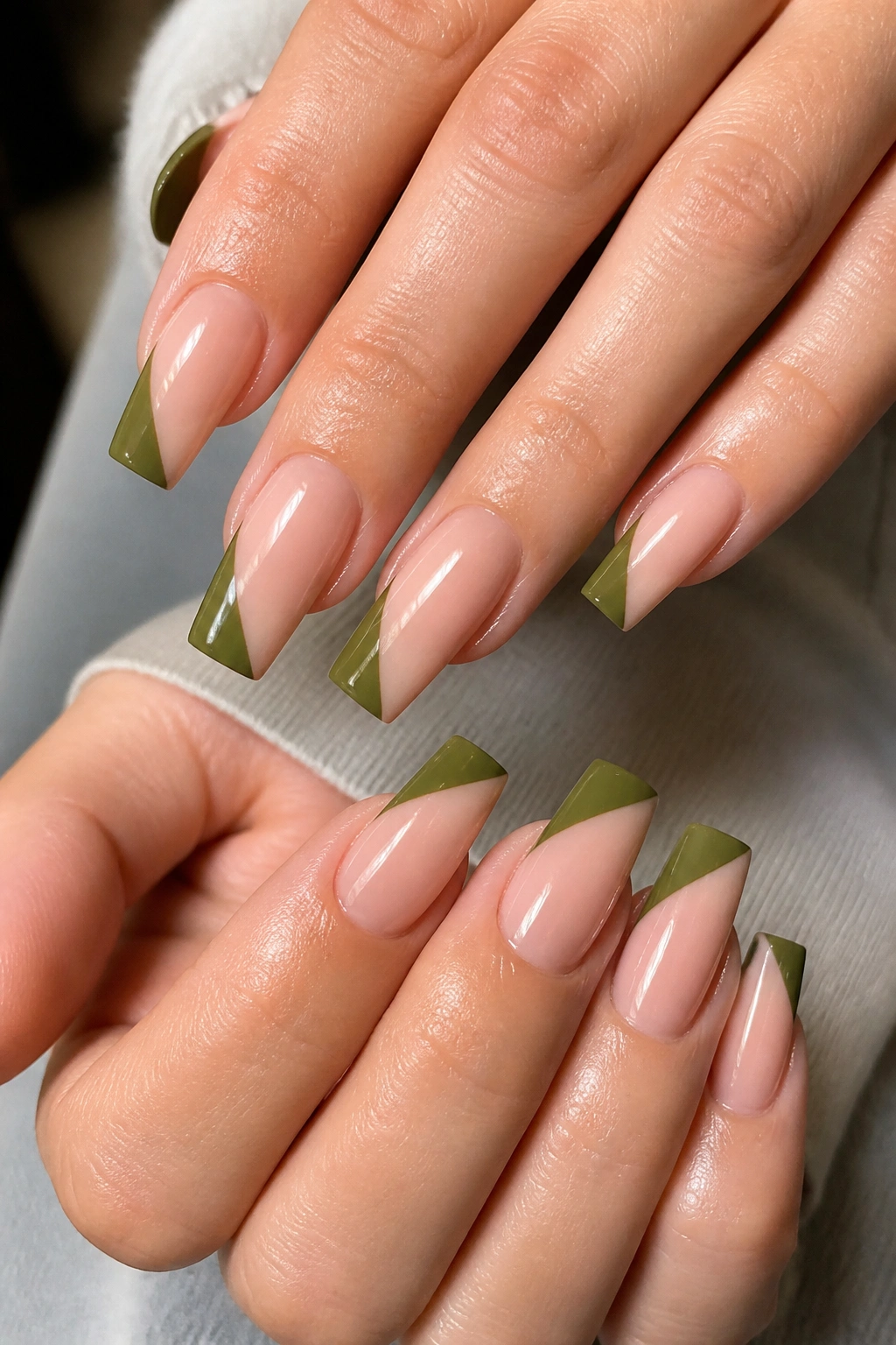 Olive diagonal French tips on coffin nails with sharp edges.