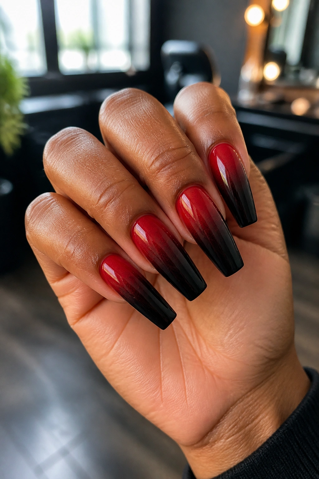 Close-up of red-to-black ombre coffin nails on a real hand