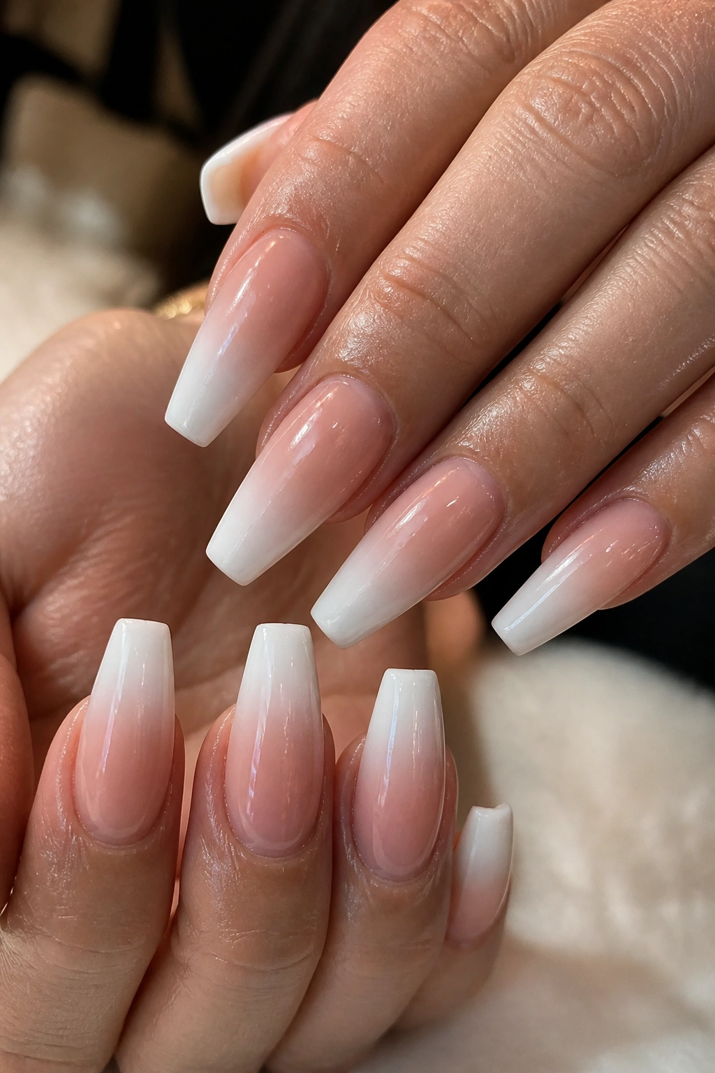 Close-up of hands with Ombre French Tip Coffin Nails showing white fading into nude