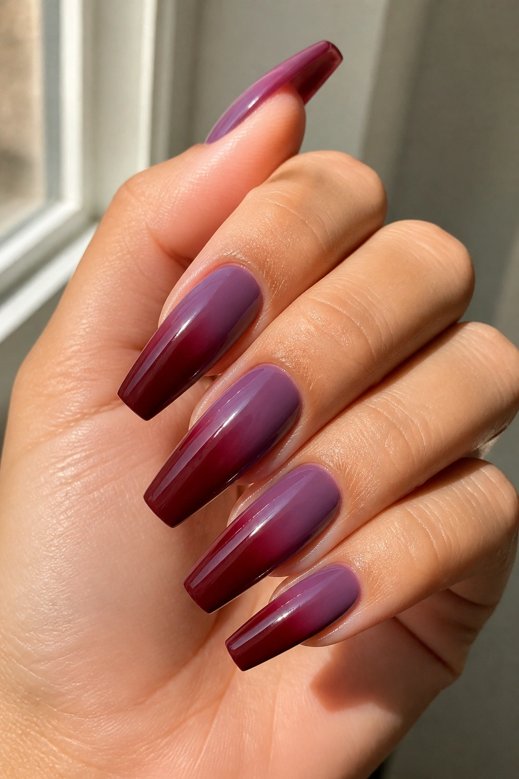 Close-up of plum-to-maroon ombre coffin nails.
