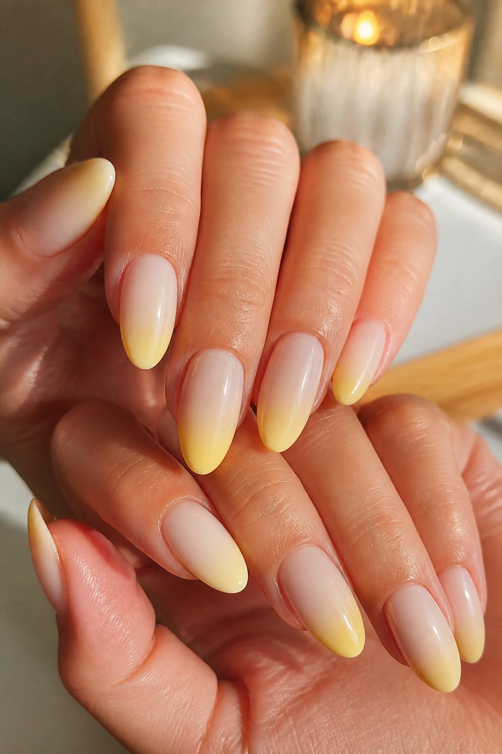 Almond nails with butter-yellow ombré into milky nude in soft daylight