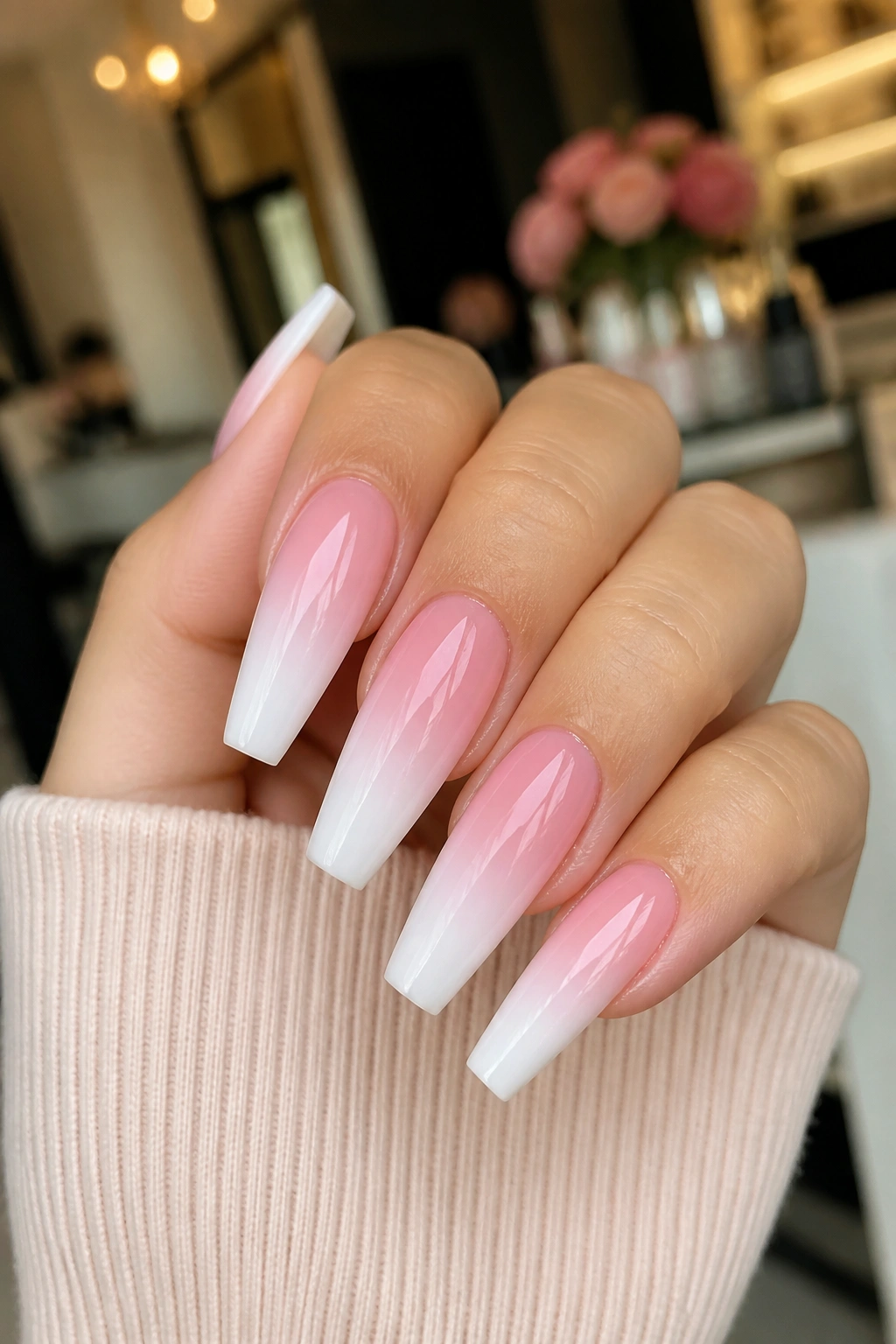 Close-up of coffin nails with pink-to-white glossy ombre on a real hand
