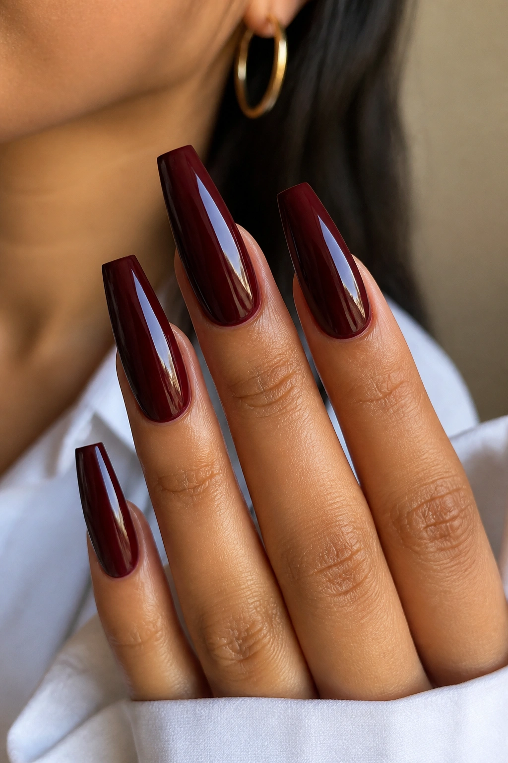 Close-up of oxblood coffin nails with glassy topcoat on a real hand