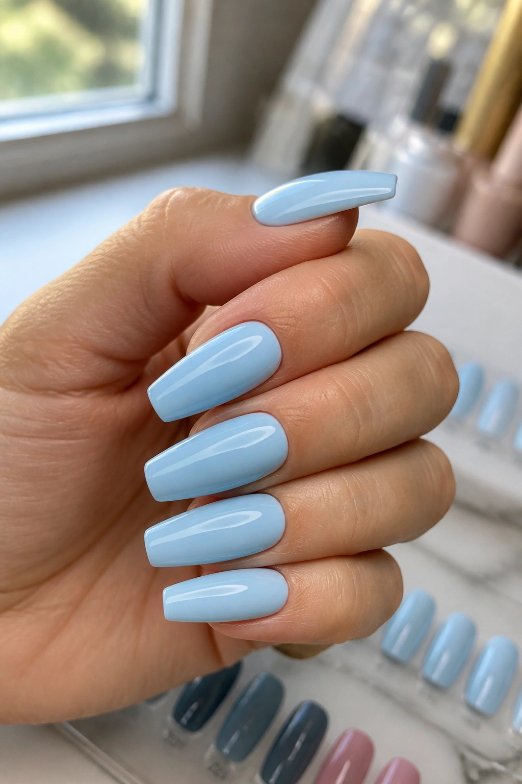 Close-up of pale blue manicure on real hand in salon setting