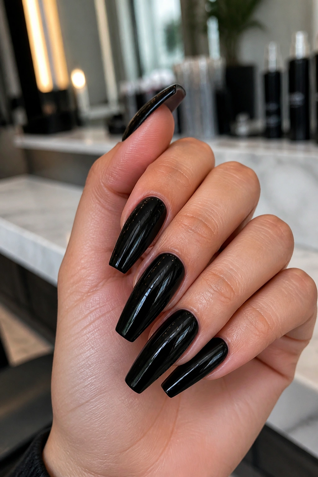 Close-up of glossy patent black coffin nails on a real hand