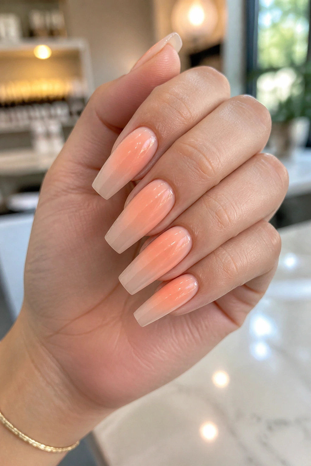 Close-up of peach aura coffin nails on a real hand in a spa setting