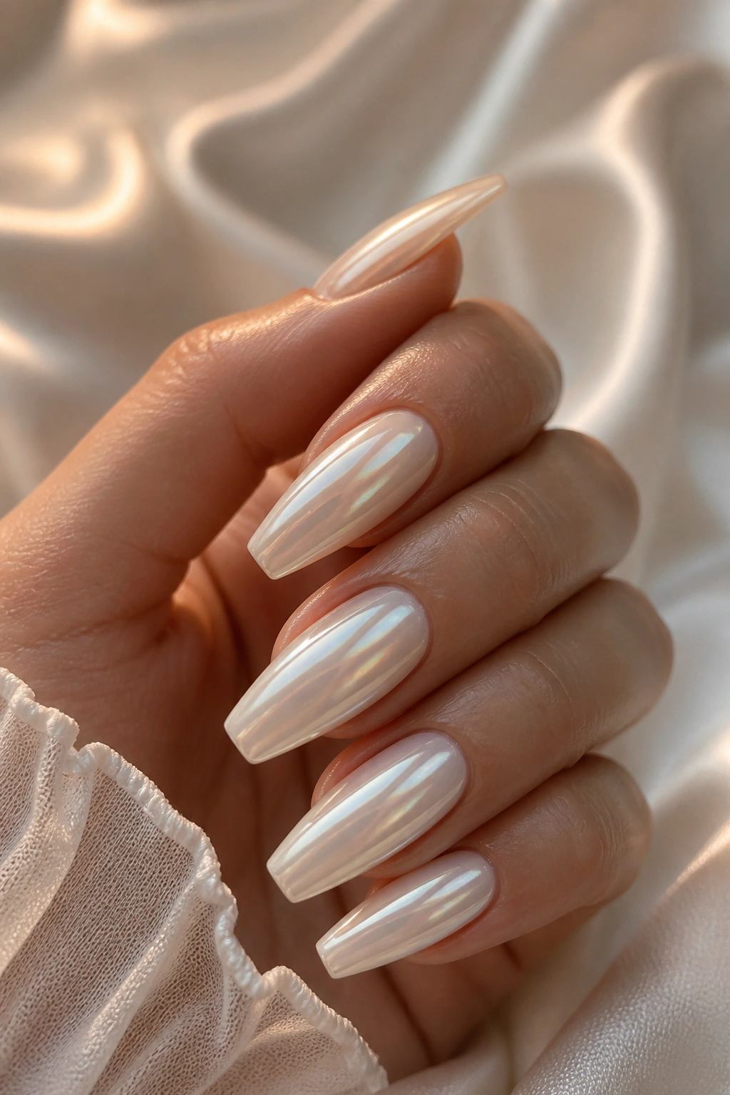 Close-up of pearl chrome coffin nails with smooth mirror sheen on a real hand