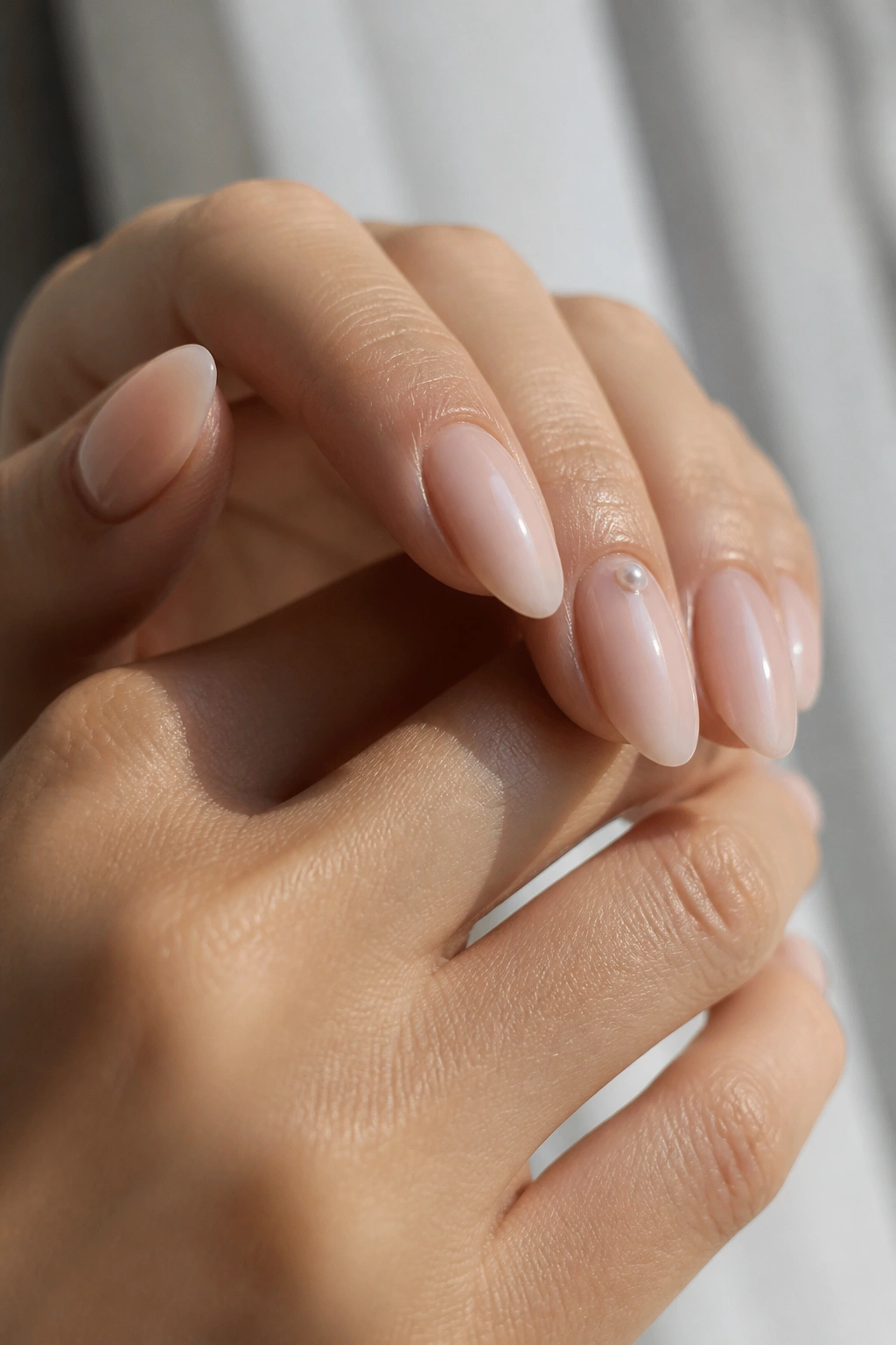 Almond nails with small pearls near the cuticle on accent nails
