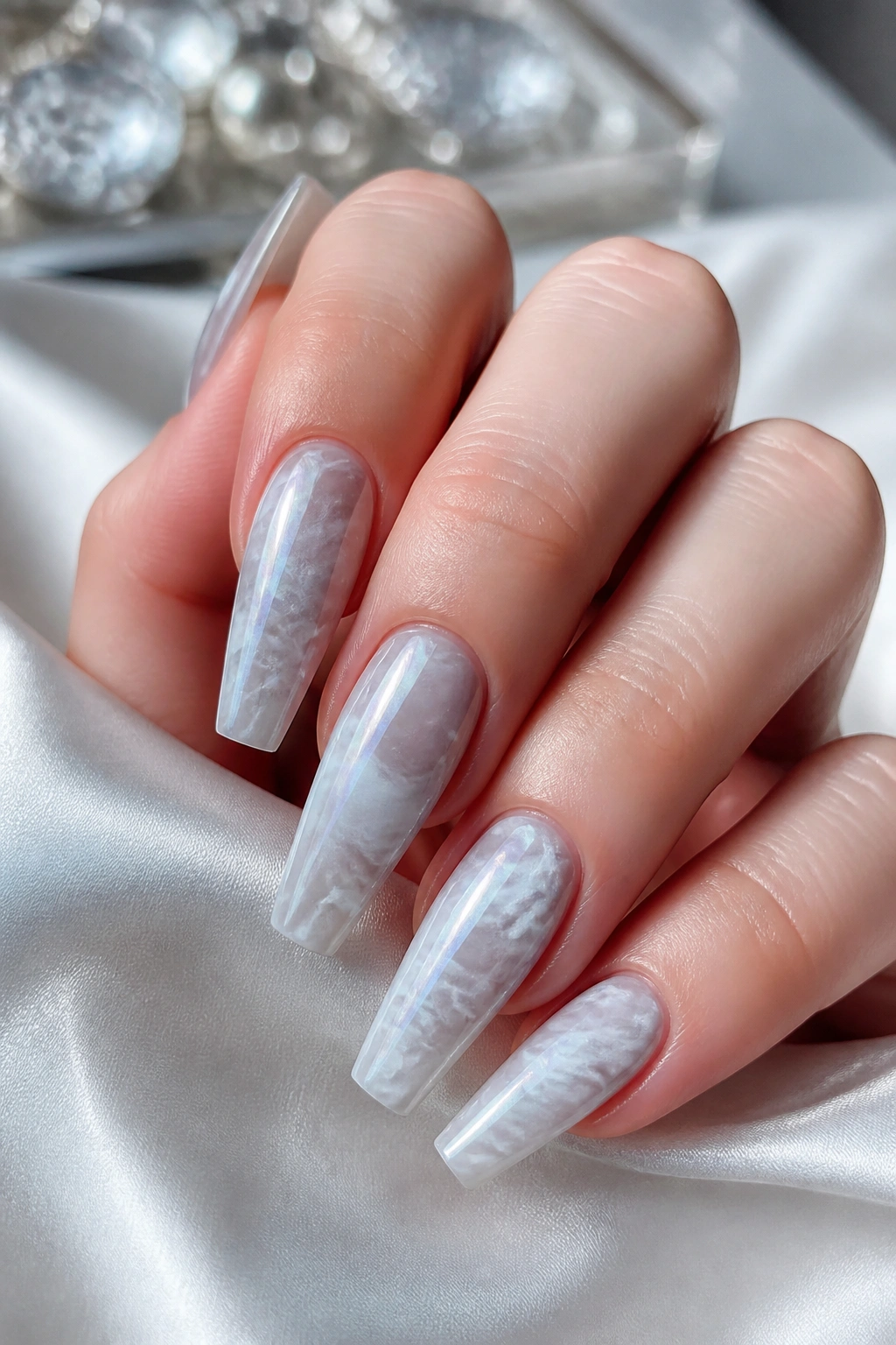 Close-up of a hand showing coffin nails with soft gray and white pearl marble design