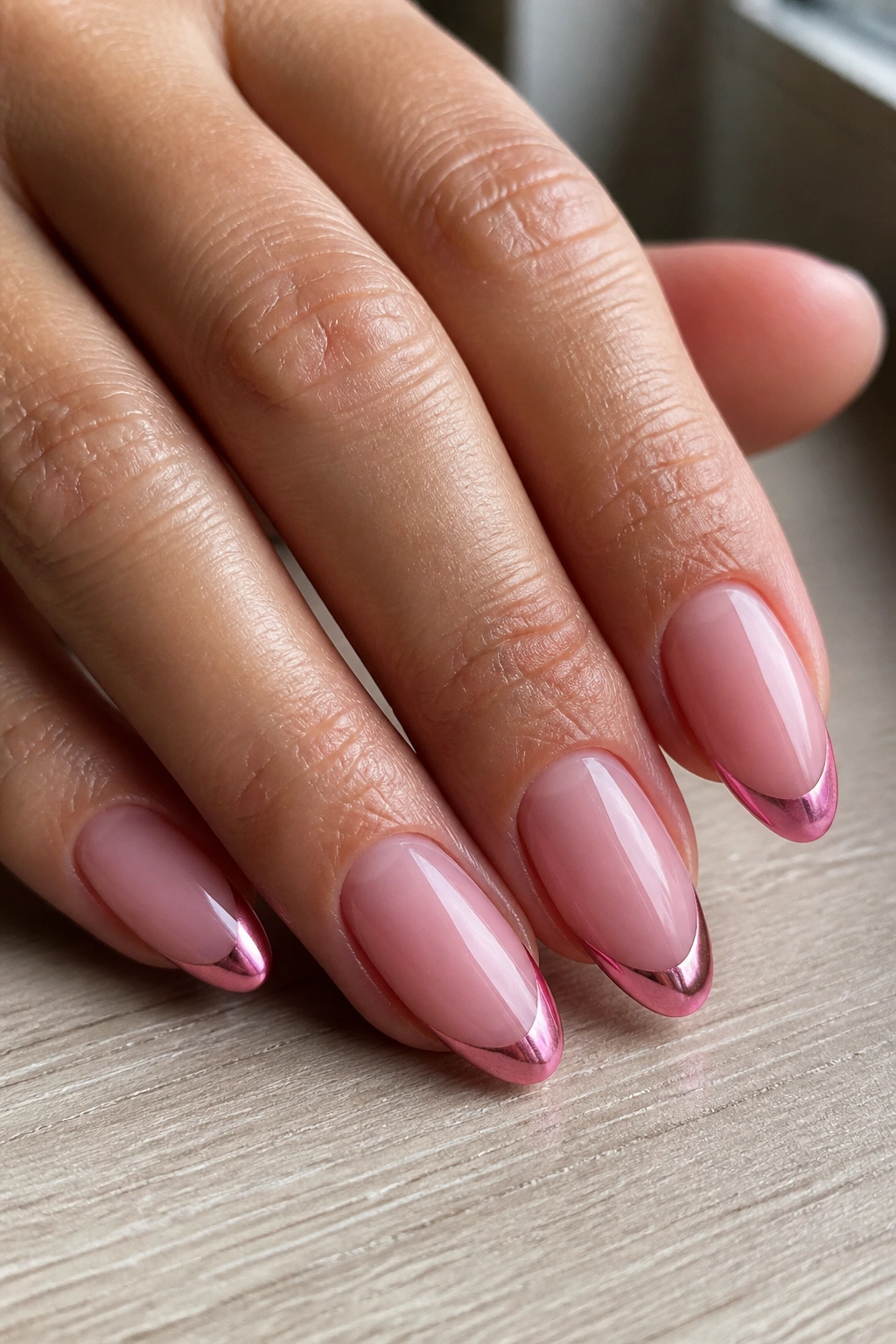 Almond nails with pink chrome tips on a pale pink base