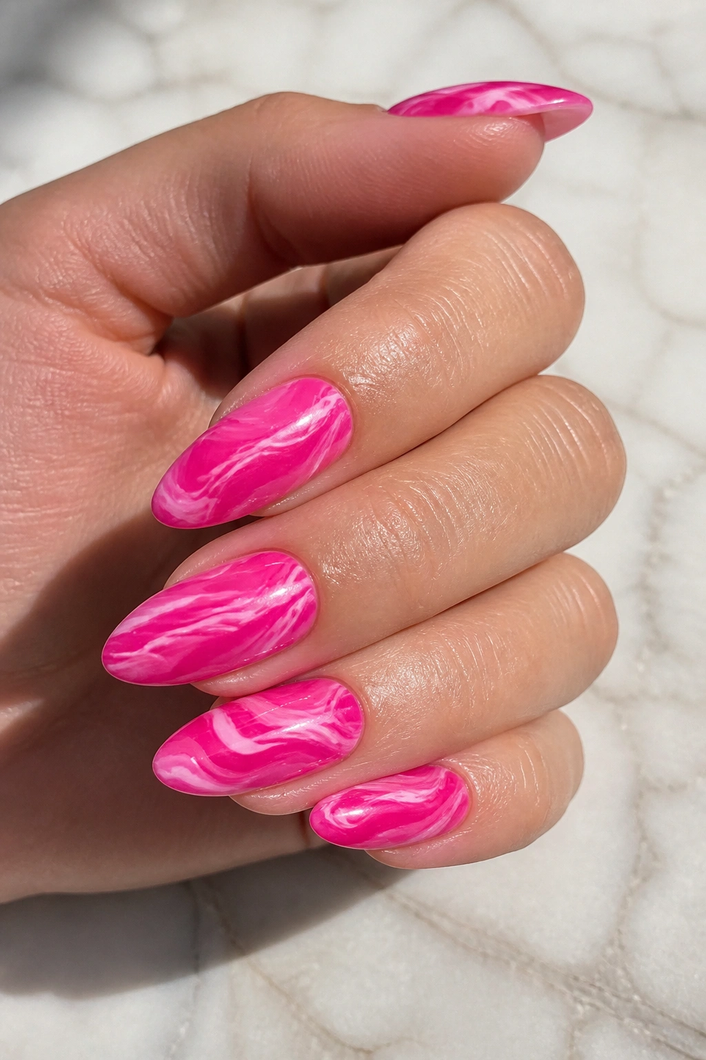Close-up of hot pink marble swirl nails on a real hand