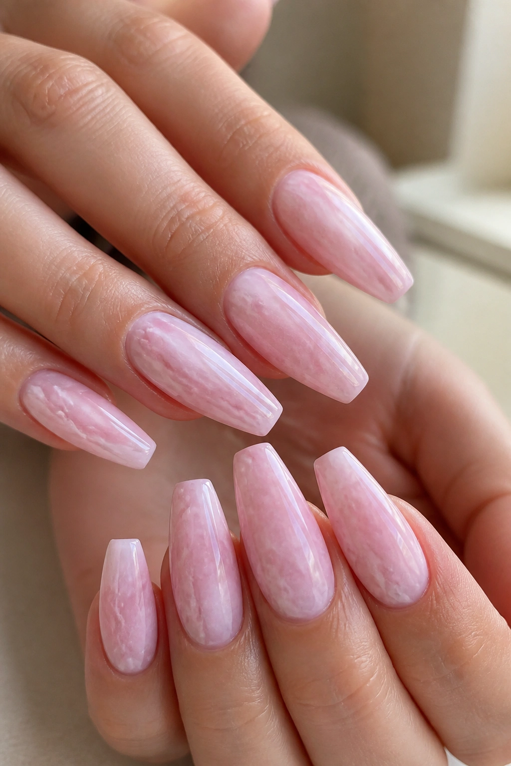 Close-up of pink quartz marble coffin nails on real hands