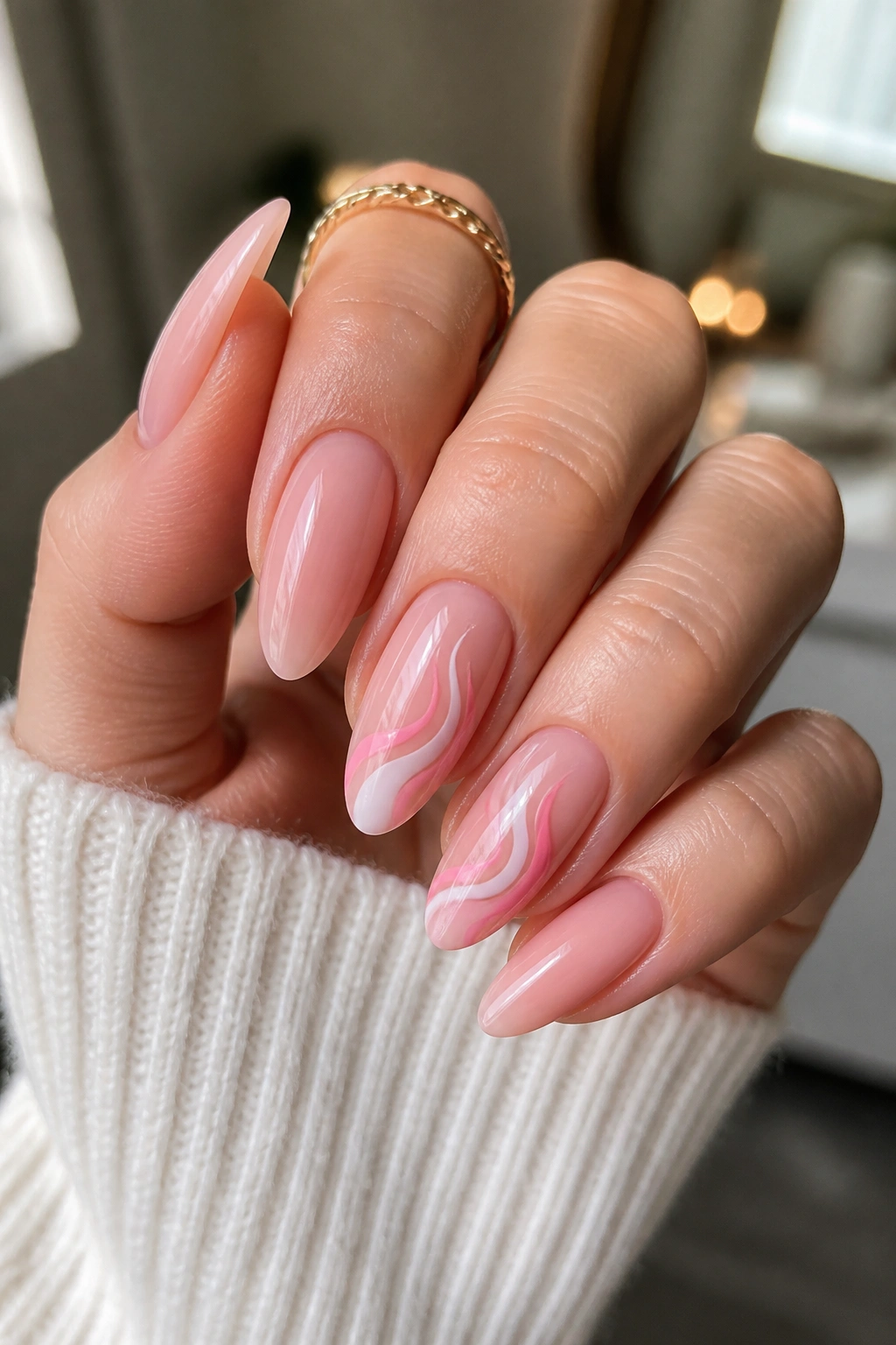 Close-up of almond nails with pink swirl tips on two to three nails