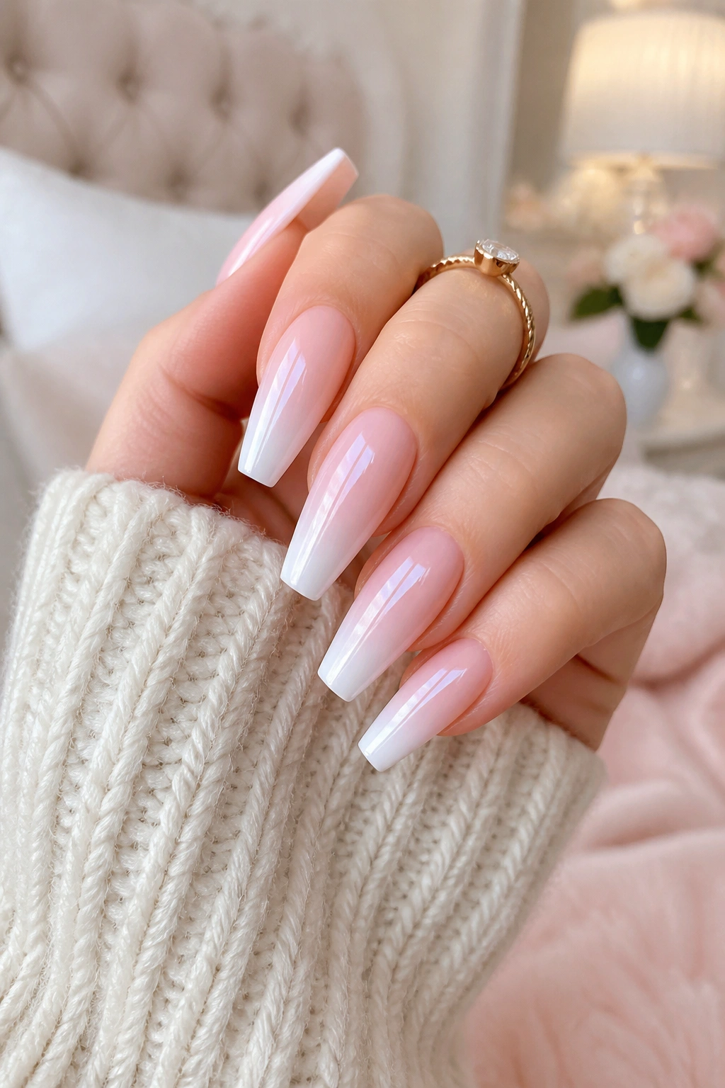 Close-up of pink-to-white ombre coffin nails with pearl on a real hand